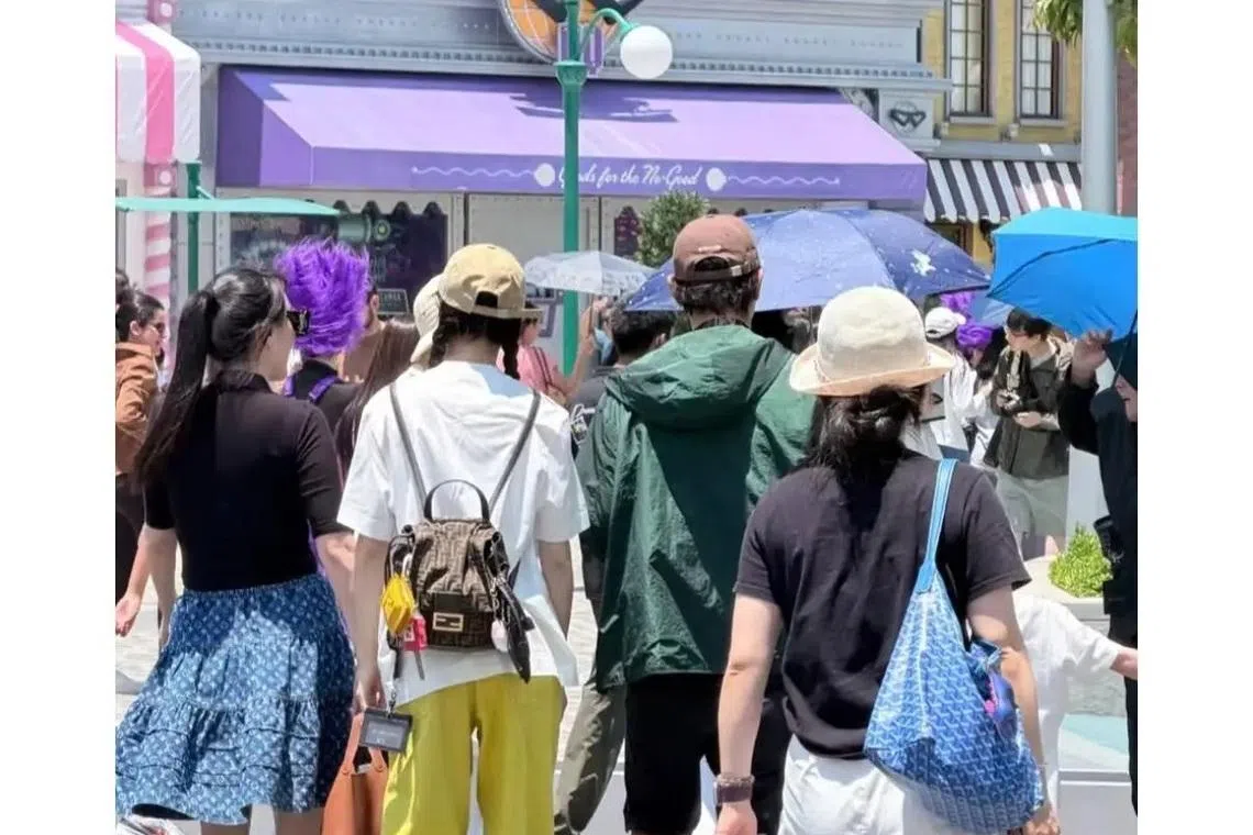 唐嫣（左二）和罗晋（左三）被网民拍到现身新加坡环球影城。（互联网）