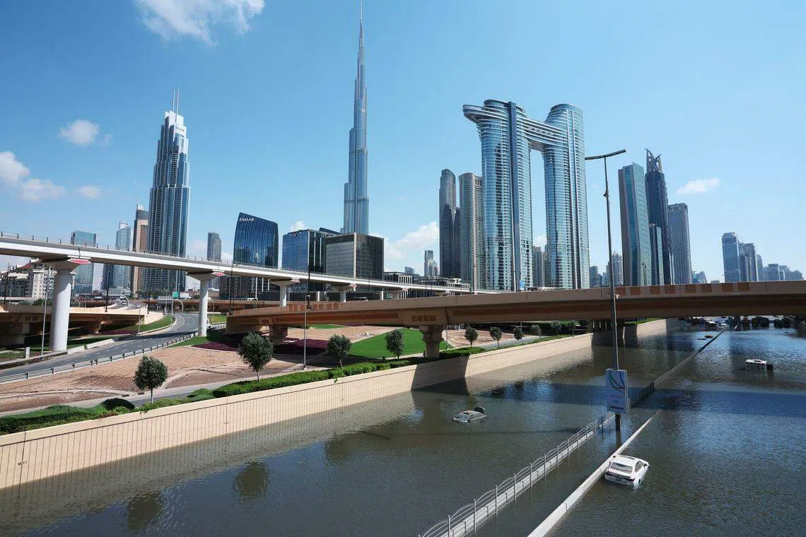 阿联酋遭遇1949年有记录以来最严重的暴雨。图为迪拜快速公路被洪水淹没，一些车子滞留在马路上。（彭博社）