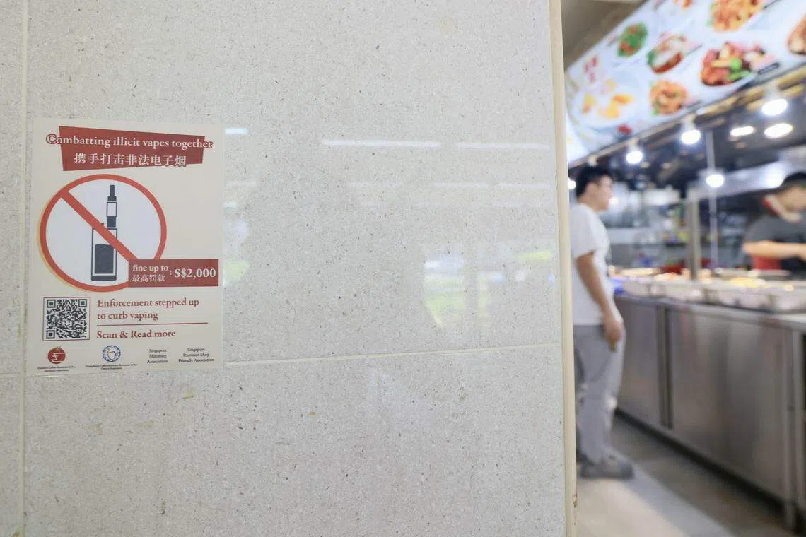 本地四个商会合作在咖啡店、杂货店和迷你市场张贴海报和贴纸，提醒公众持有、购买和使用电子烟和加热烟草产品，均属违法行为。（郑一鸣摄）