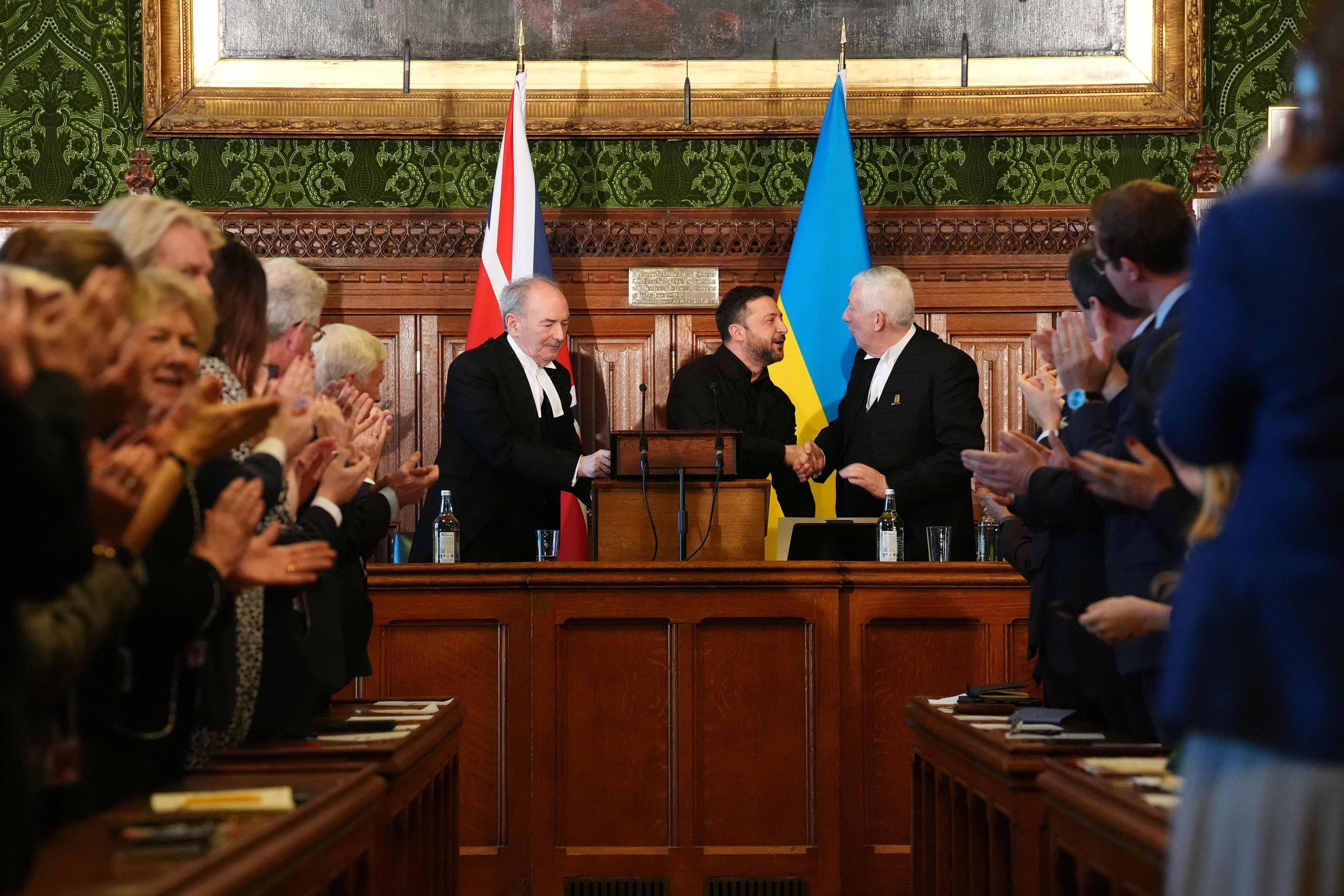 泽连斯基在威斯敏斯特宫演讲完毕，英国议会下议院议长霍伊尔（右）向他表示祝贺，全体议员为他起立鼓掌。（法新社）