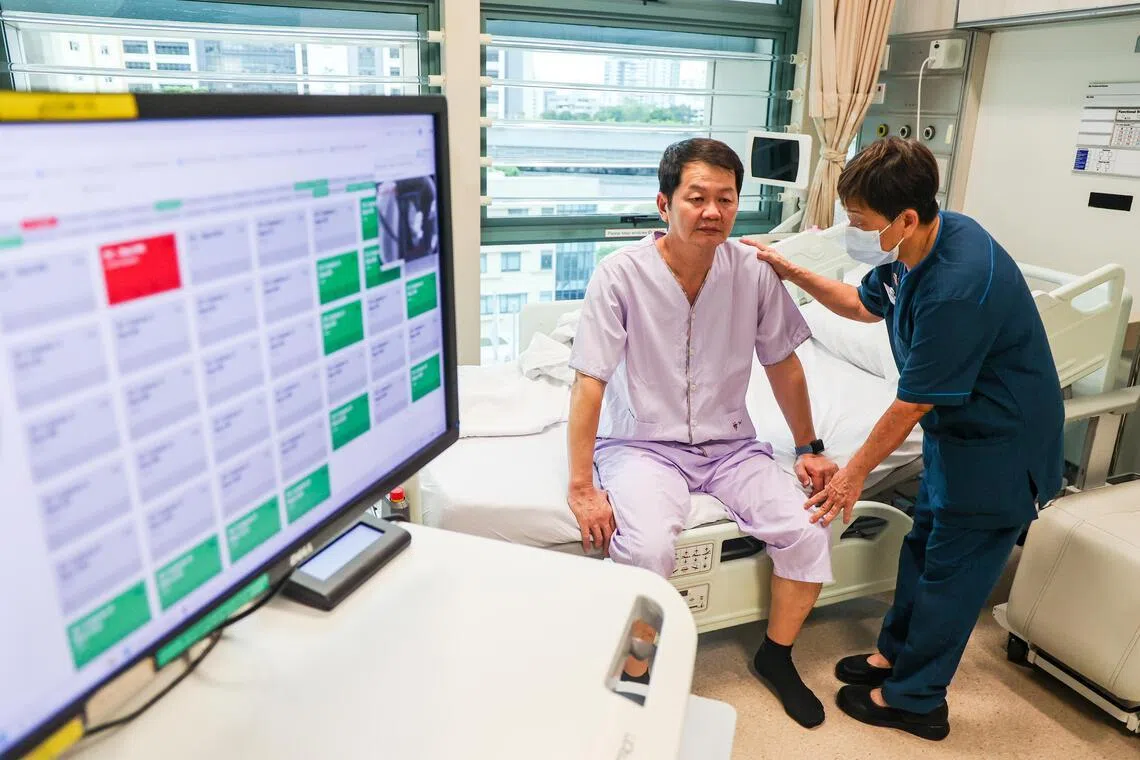 跌倒预警系统利用热感器，辨识病患下床前的特定动作，并发出警报（荧幕红色），呼叫值班护士及时赶到床前，以防病患跌倒。图为高级助理护士丁玩华，演示检查模拟病患的状况。（陈斌勤摄）