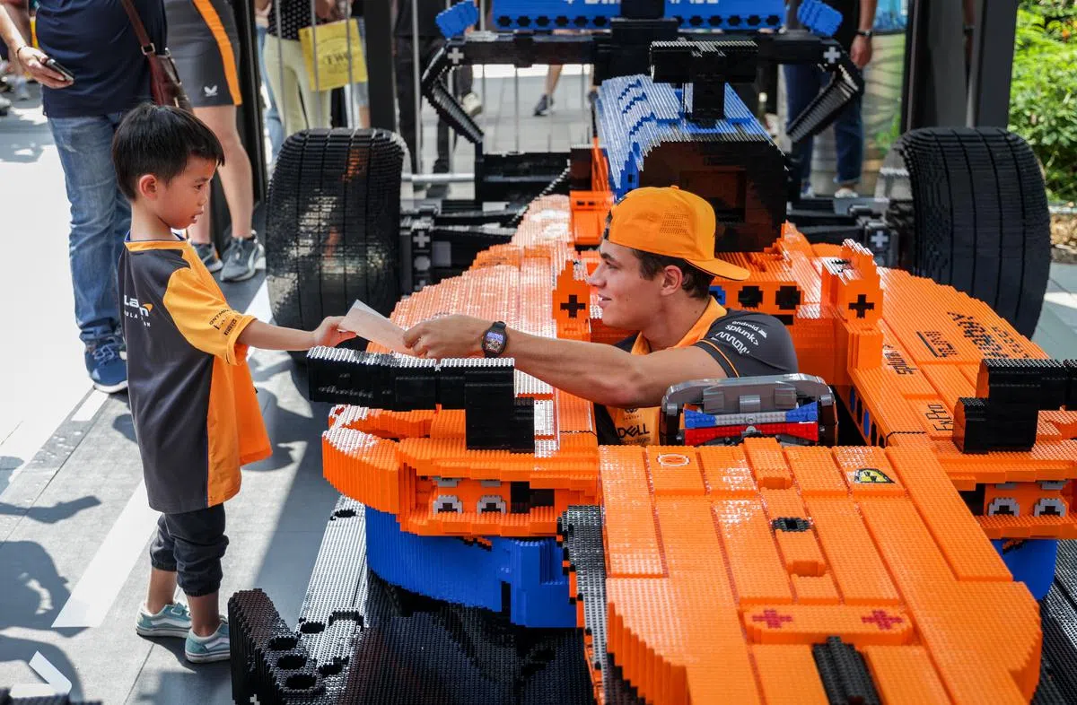 迈凯伦车手诺里斯日前在出席乐高积木活动时，亲切地为小小车迷签名。（叶振忠摄）