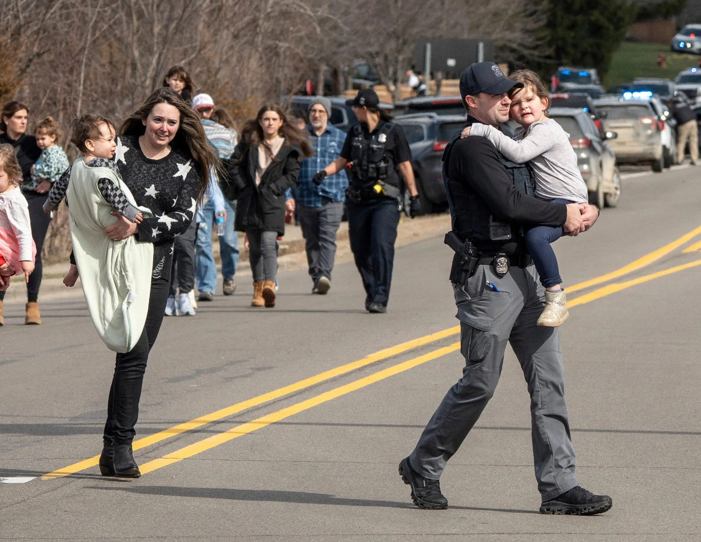3月12日，在密歇根州西布卢姆菲尔德，一名嫌疑人驾驶卡车撞入以色列圣殿犹太教堂的走廊后，执法人员带领家长护送孩子返回各自的车辆。（路透社）