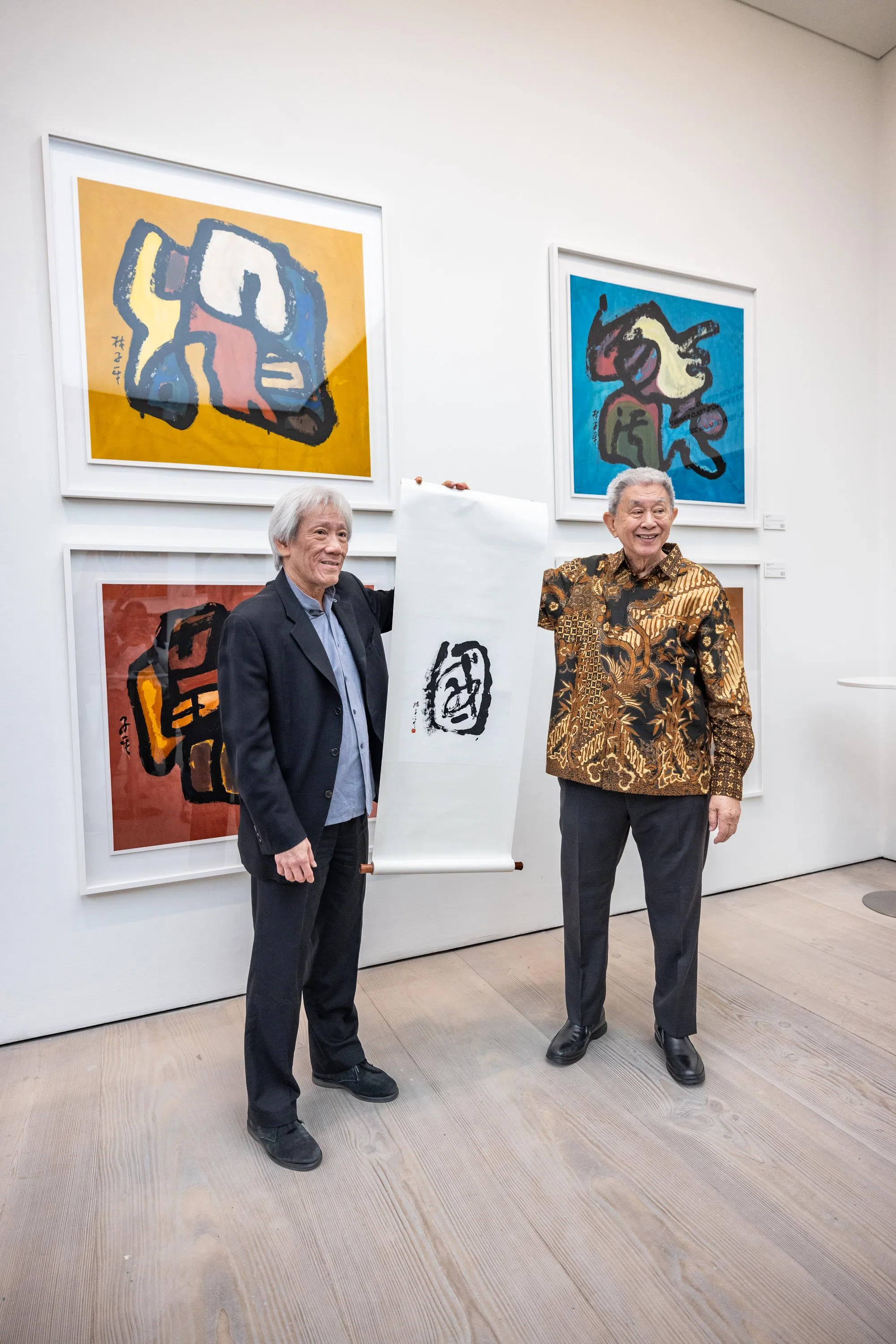 林子平因年事高无法赴英，由大儿子林树国（右）代表画家赠字《国》给新加坡驻英国最高专员林传权。（主办方提供）