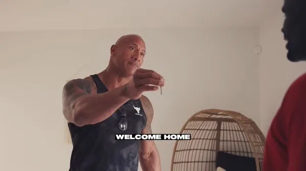 巨石强森惊喜将房子锁匙交给戈林博，让对方错愕。（互联网）