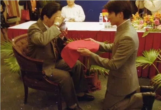 刘德华（右）跪地奉茶，向彭登怀拜师。（互联网）