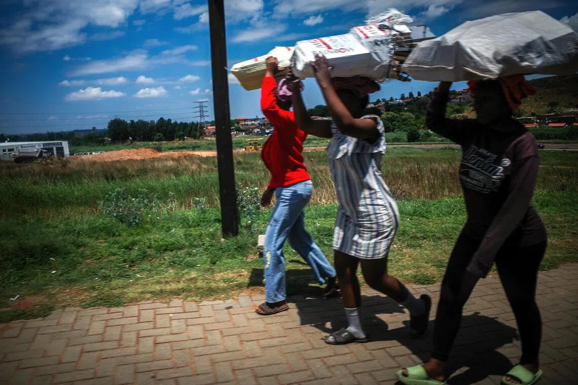 烈日下，前行的背影，肩负着日常的重量，步伐不停。（叶振忠摄）