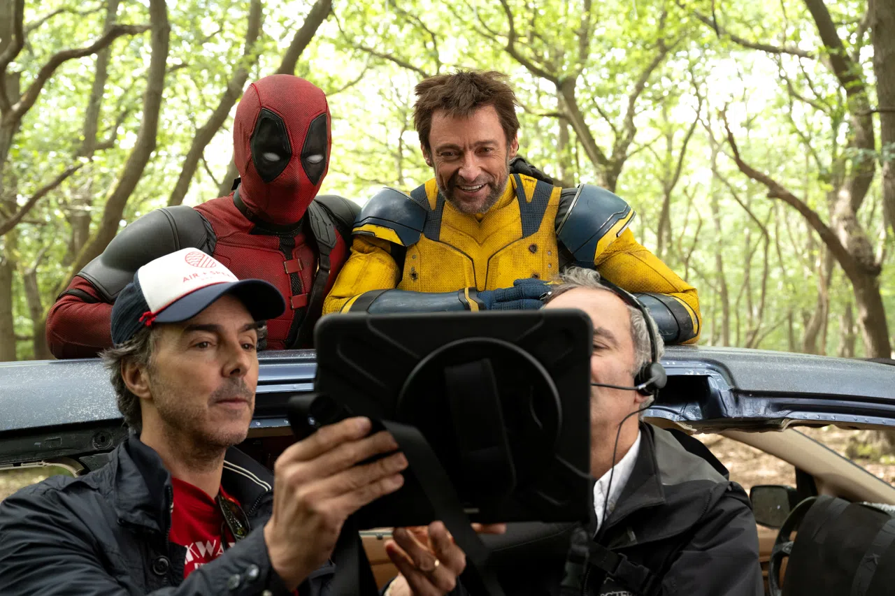 Ryan Reynolds（后排左起）、Hugh Jackman和导演Shawn Levy（前排左）一起看回放带。（迪士尼提供）