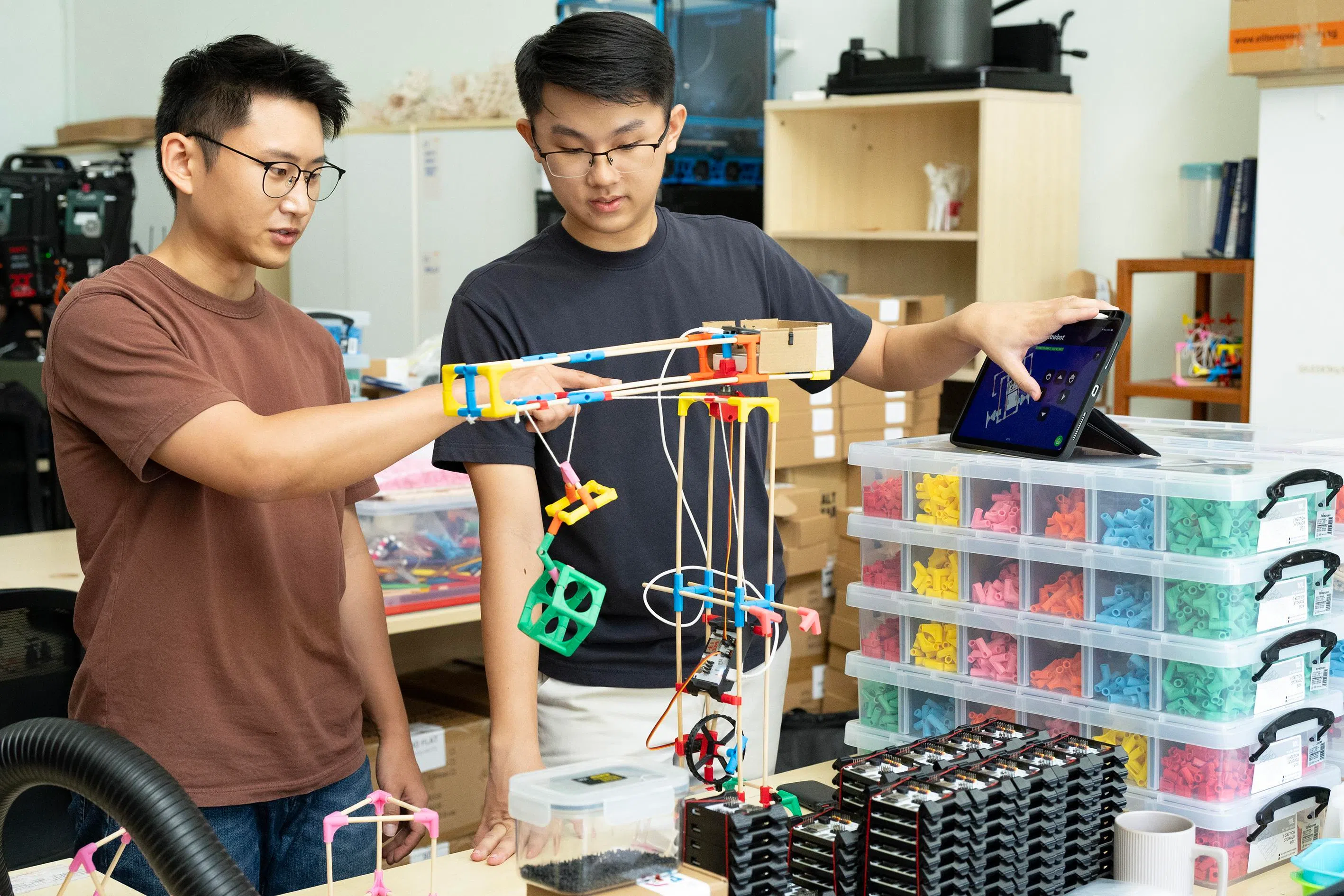 韩丹（左）正与公司联合创办人锺英凯讨论如何将承重绳穿入Stick‘Em的起重系统。（档案照片）