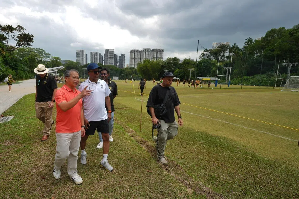律政部长兼内政部第二部长唐振辉（左一）参观翻新后的足球草地。俱乐部重做排水系统并改为沙基结构，2024年起重铺草皮，以提升场地质量。（谢智扬摄）