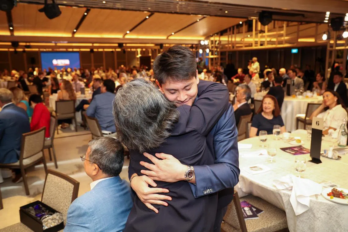 约瑟林（面向镜头者）在上台前与母亲严锦美紧紧相拥。上台后，他也感谢了母亲为支持他追梦所做出的牺牲。（关俊威摄）