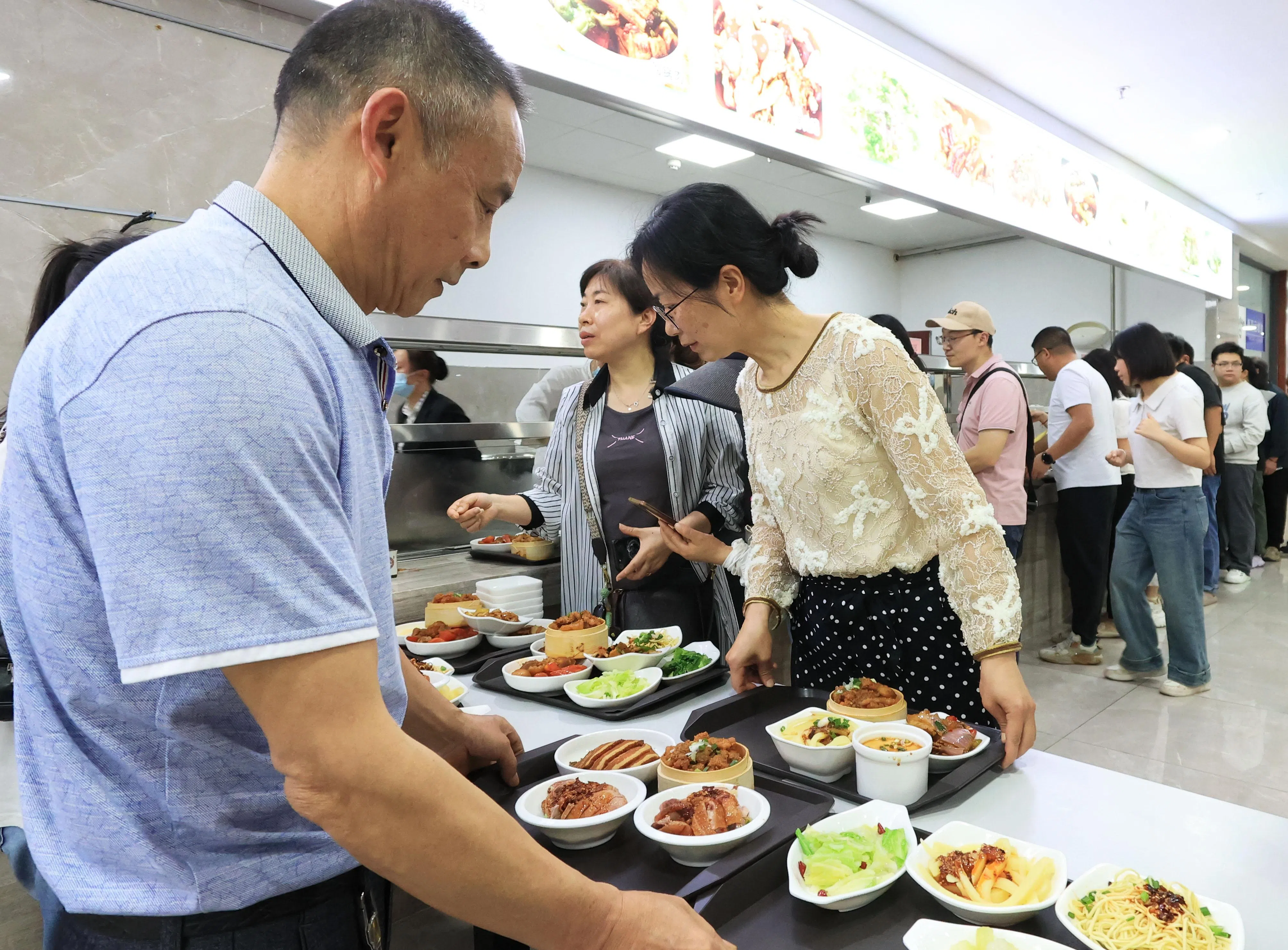 游客在重庆市荣昌区政府机关食堂选取小碗菜。（中新社）