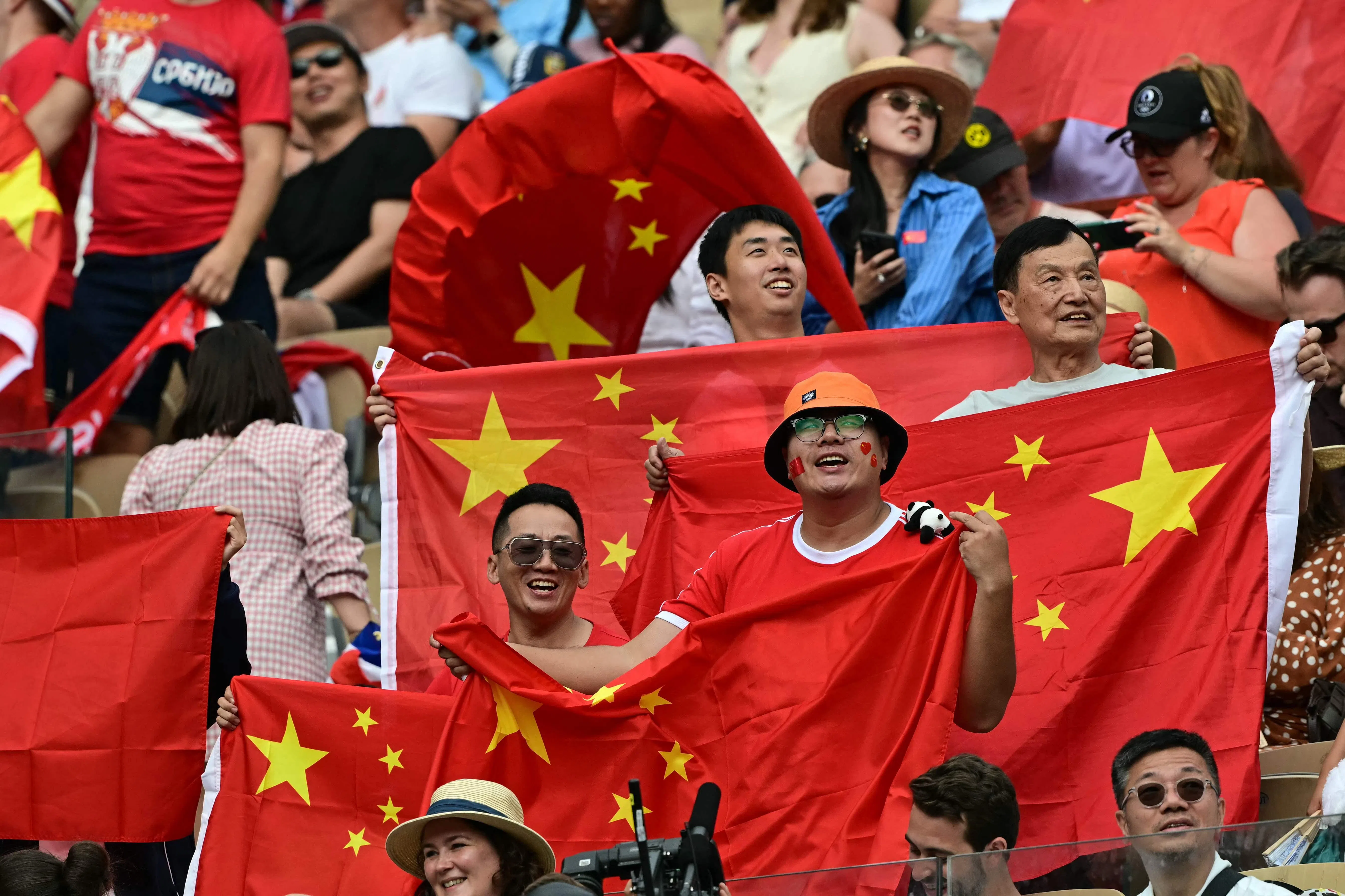 中国球迷手持国旗，为郑钦文加油，并在最后见证历史。（法新社）