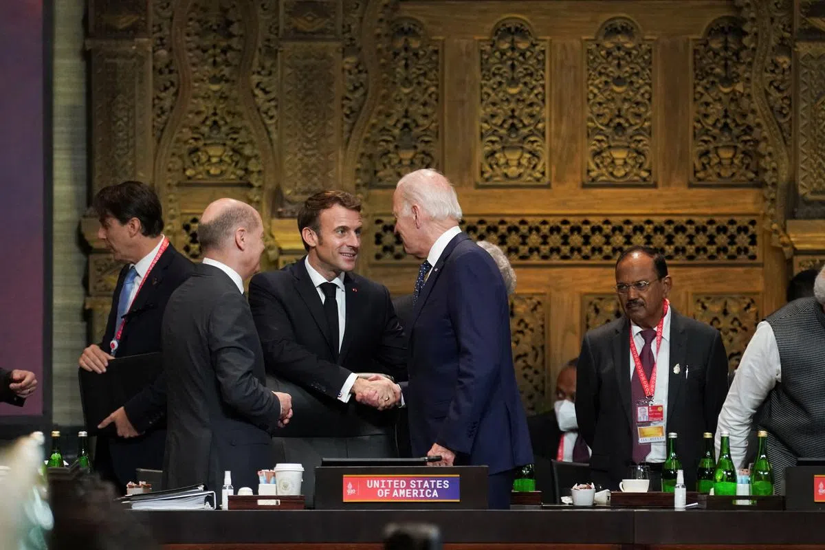 美国总统拜登（中）星期二（11月15日）在二十国集团（G20）领导人峰会首场工作会议上，与法国总统马克龙（左三）和德国总理朔尔茨（左二）交谈。（路透社）