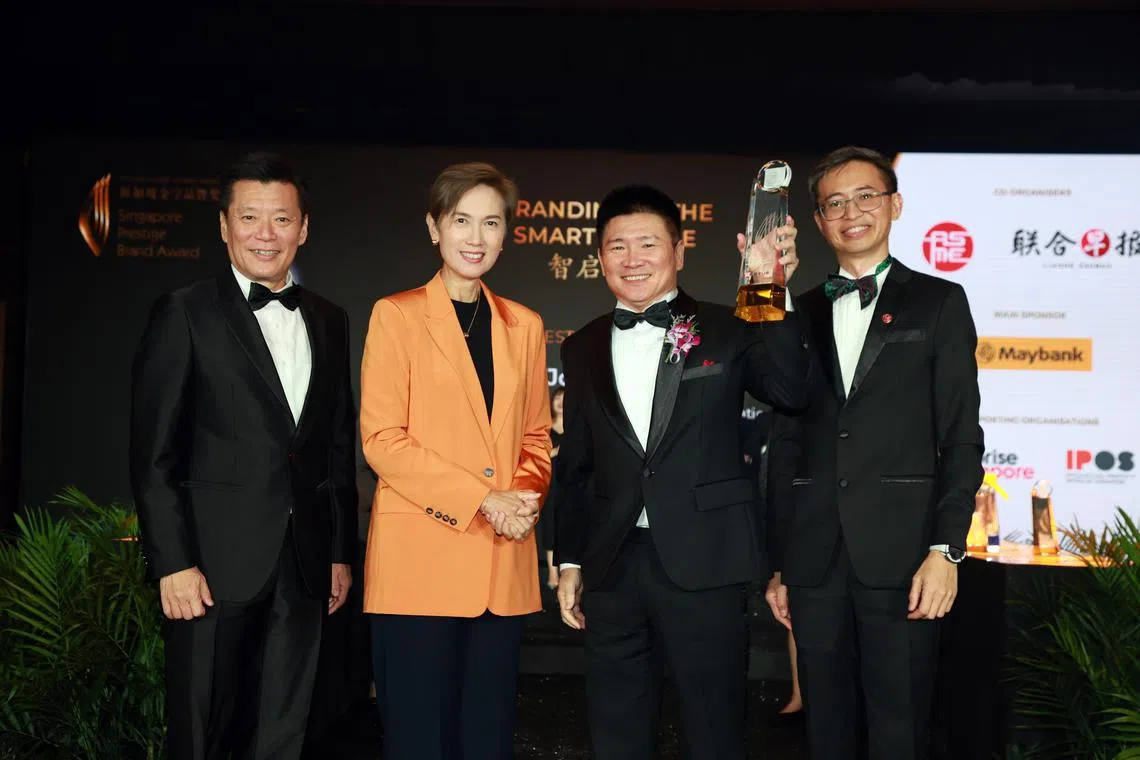 成名品牌总冠军店小二创办人叶权坤（右二）与主宾数码发展及新闻部长杨莉明（左二）、《联合早报》总编辑吴新迪（左一）和中小企业商会会长洪煜（右一）。（邝启聪摄）