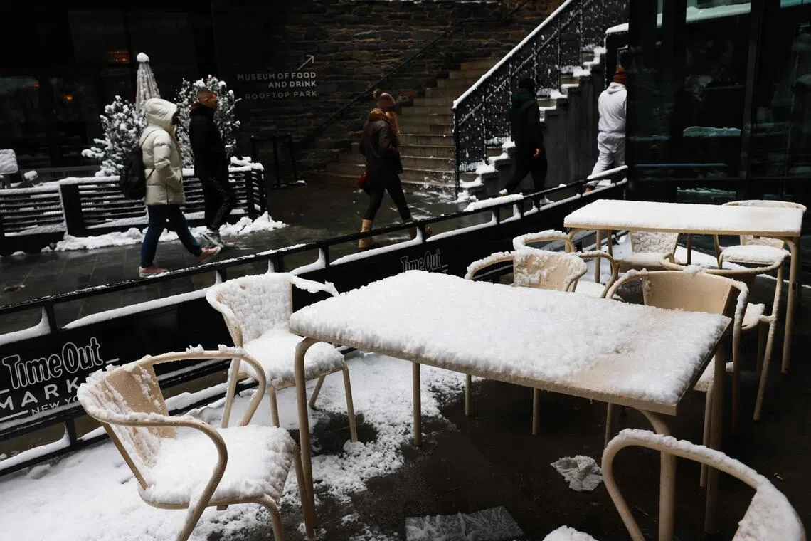 星期六（12月27日)，纽约市经历一夜暴雪后，布鲁克林区有餐馆摆放在室外的桌椅都铺上一层雪。（法新社）