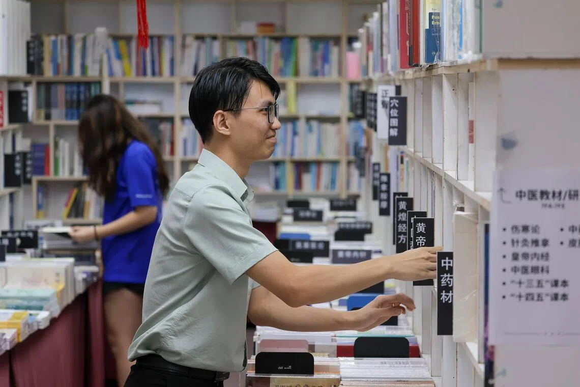 萧宇淮现在的目标是当好书店“引路人”，记住每本书的位置。（张俊杰摄）