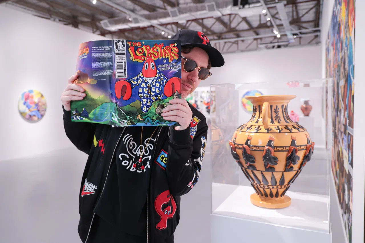 菲利普·考尔伯特全身行头与龙虾相关，图为他与陶罐合照。（李冠卫摄）