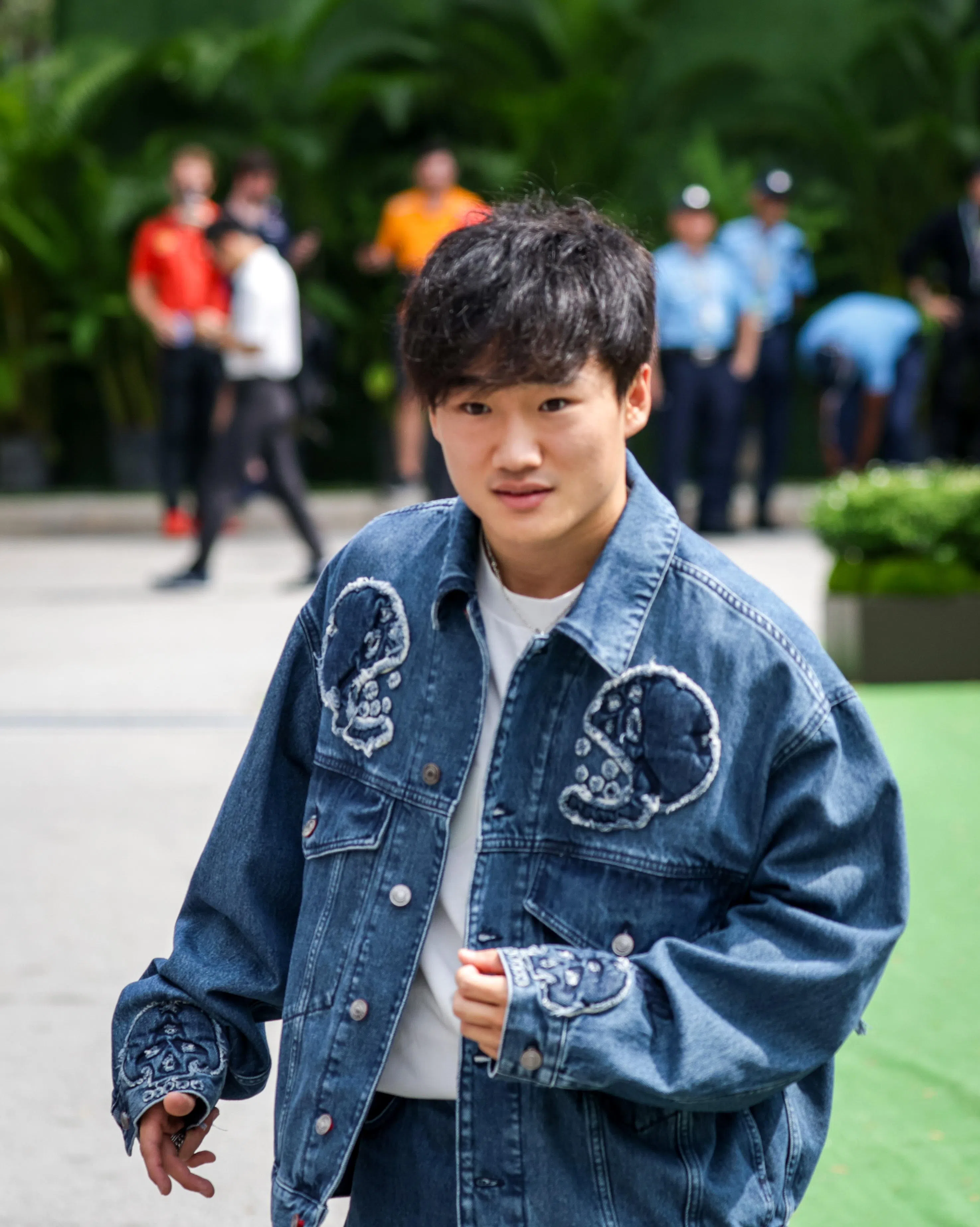 和其他车手身穿车队服不同，红牛二队车手角田裕毅穿着时尚夹克抵达F1围场。（叶振忠摄）