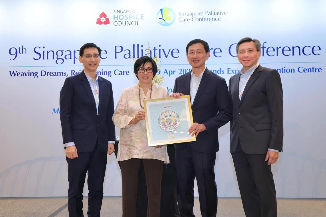 从医超过30年的圣安德烈社区医院医疗总监李安琪医生（左二），星期六从社会政策统筹部长兼保健卫生部长王乙康（右二）手中接过新加坡慈怀终身成就奖。 右一为新加坡慈怀理事会主席周永明；左一为提名人兼慈怀理事会荣誉秘书余辉耀教授。（梁麒麟摄）