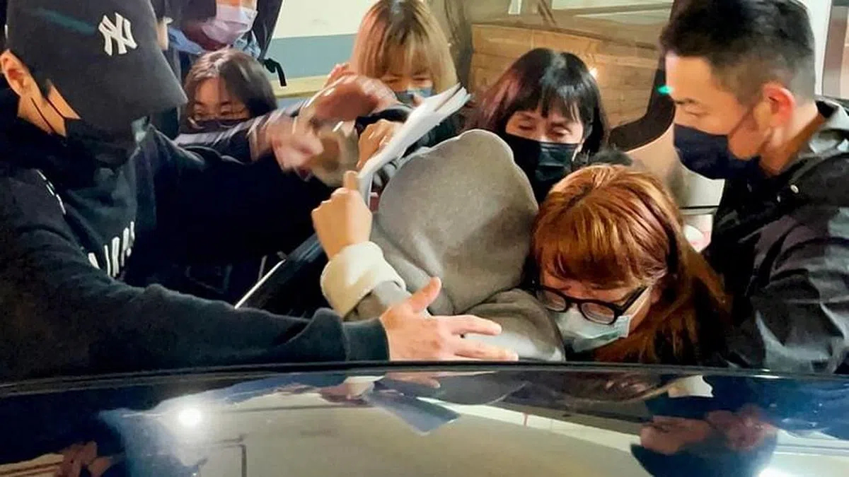 明金成的妻子林沛缔（灰色连帽大衣）在结束相验后搭车离去。（互联网）