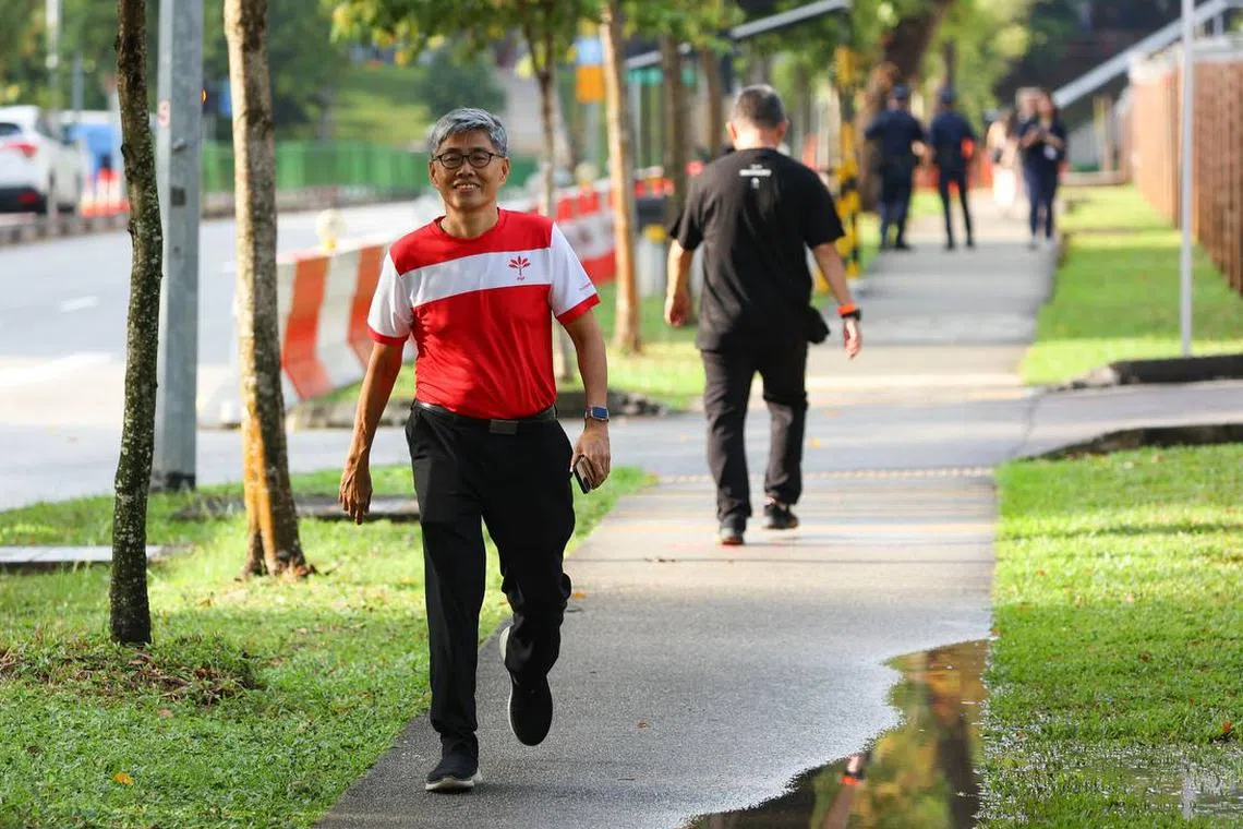 新加坡前进党候选人陈礼添（左）星期三早上抵达德义中学提名站。（关俊威摄）