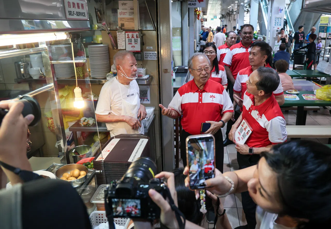 新加坡前进党主席陈清木医生（前排左二）将领军前进党西海岸—裕廊西团队。他星期天与团队成员梁文辉（前排右一）、潘群勤（第二排左）、乐吉（第二排右）和萨尼（第三排），一同走访达曼裕廊巴刹及熟食中心。（张俊杰摄）