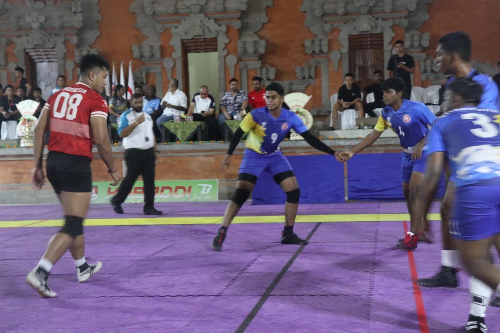 我国卡巴迪男队队长德威（9号蓝衣）很享受比赛中和队友联手作战扑倒来犯对手的感觉，或者当攻击手时独自闯入敌方领地“以一敌众的刺激感”。（受访者提供）