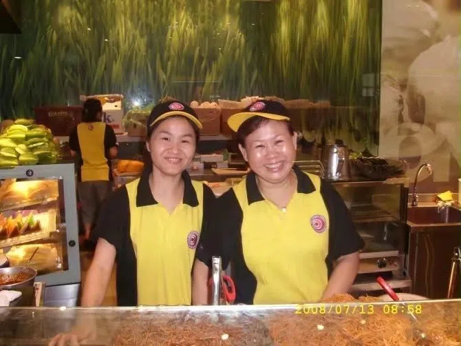 金淑娟（左）在经济米粉摊位工作时，与同事留下的合影。（受访者提供）