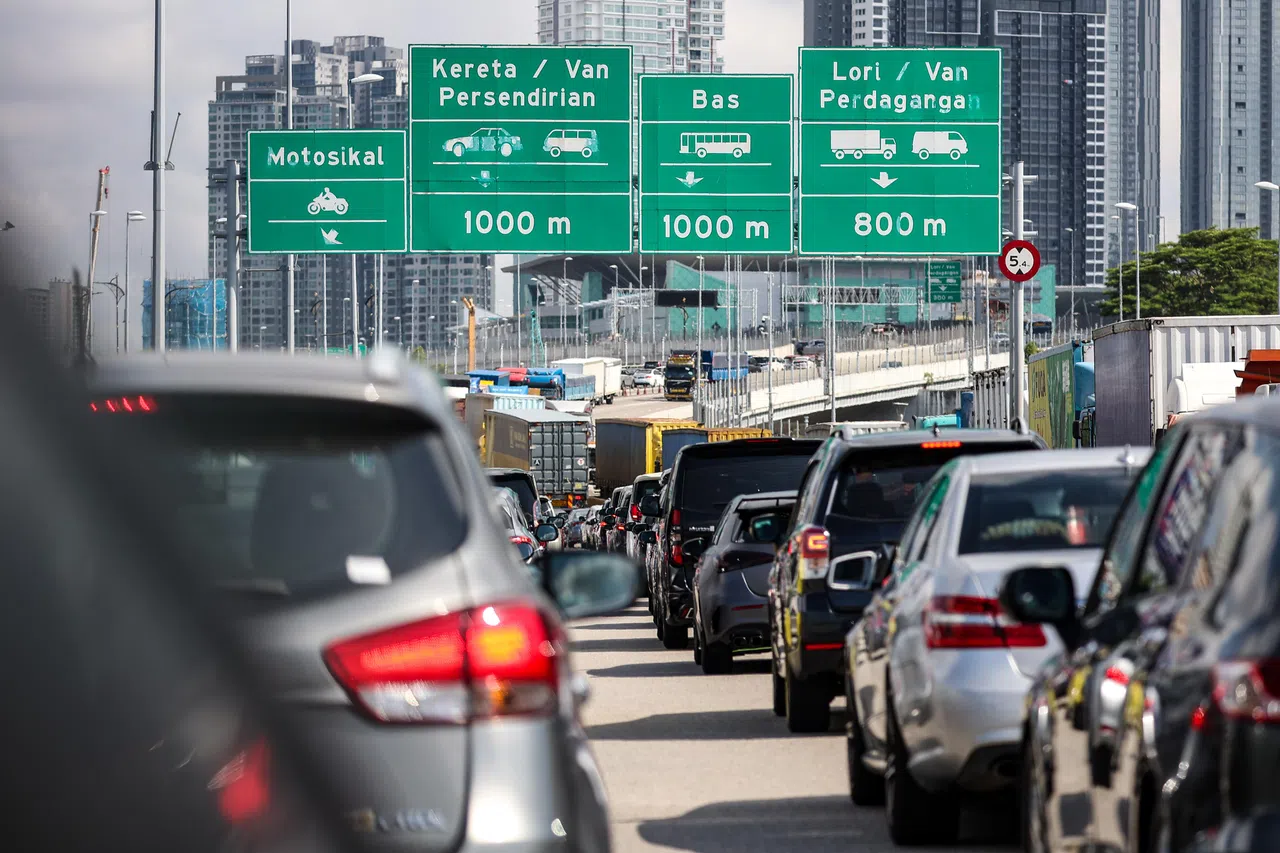 上午11时左右，不少车辆在通过兀兰关卡后还是堵在新山关卡前。（关俊威摄）