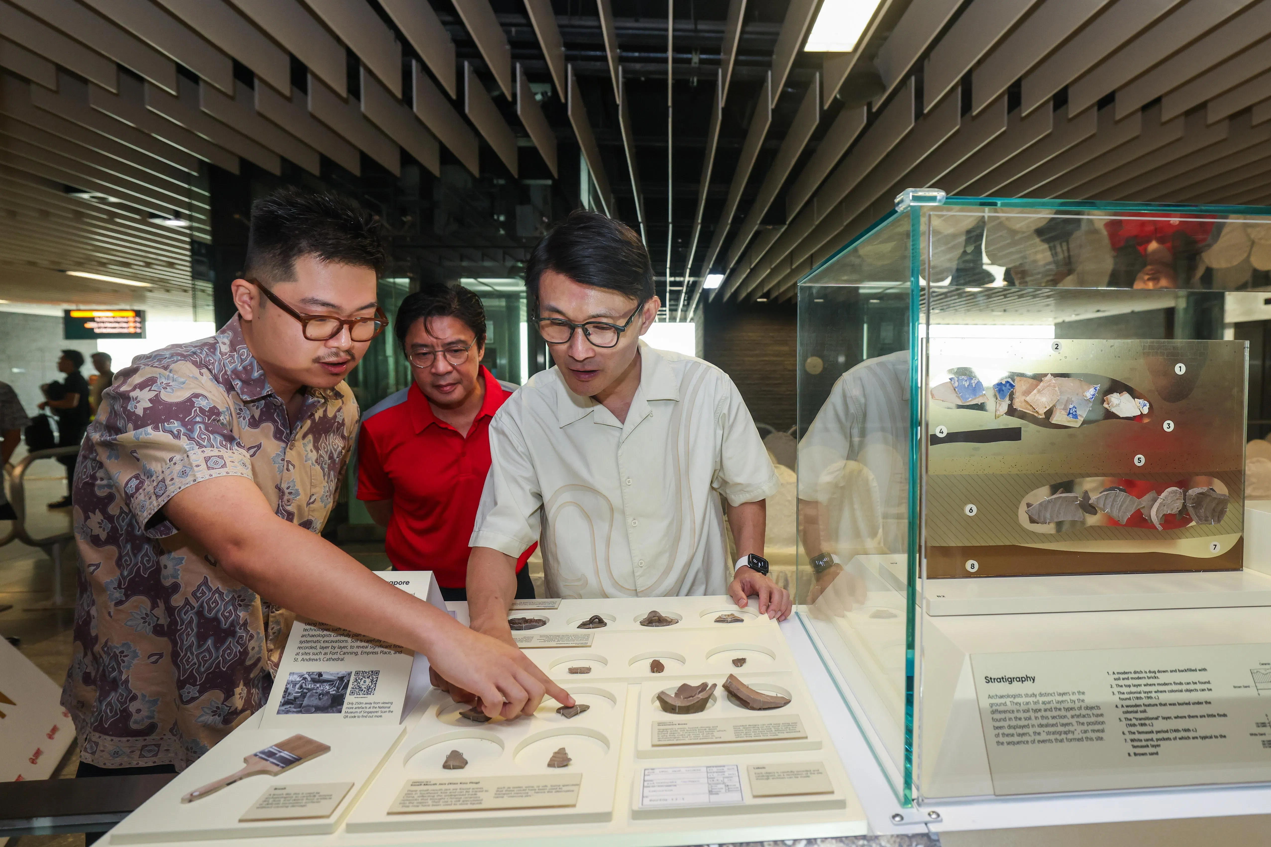 国家文物局文化遗产政策和研究副经理沈冠雄（左一）向交通部兼文化、社区及青年部政务部长马炎庆（左三）介绍展出的文物。SMRT集团首席乘客体验与服务质量官揭育文（左二）也出席活动。（白艳琳摄）