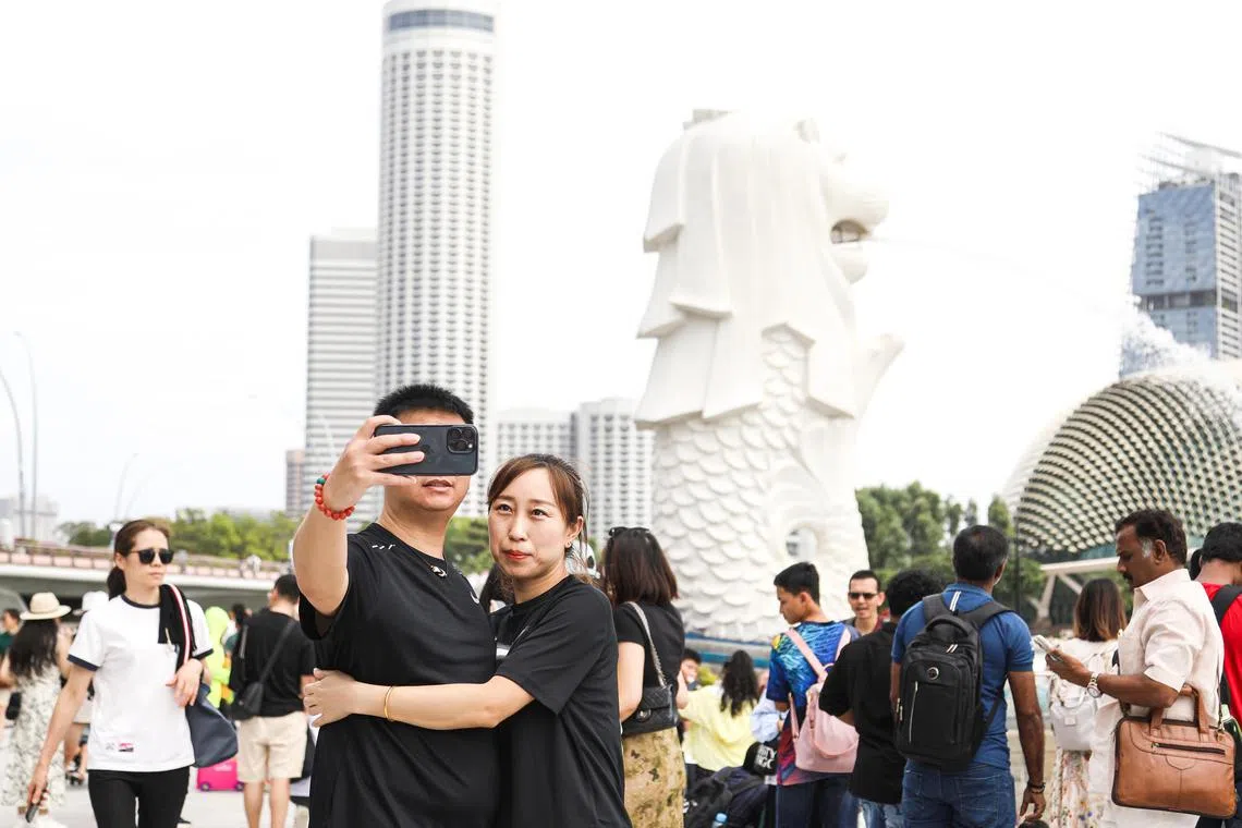 大年初二中午，来自世界各地的游客在鱼尾狮公园拍照留念，其中不乏来本地过年的中国游客。（刘欣怡摄）