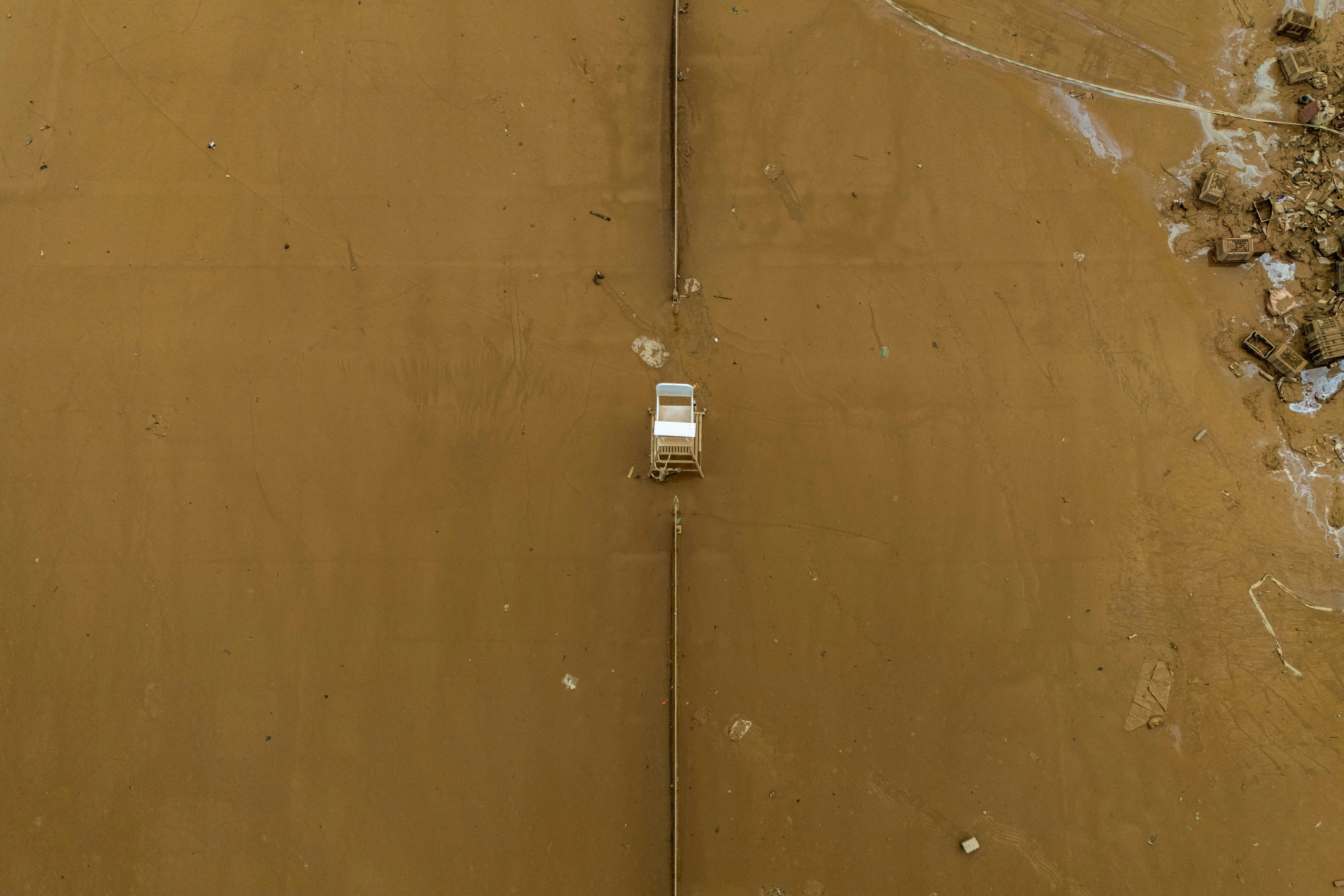 合艾的一座网球场被污泥和洪水淹没，一张裁判椅倒在地上。（路透社）