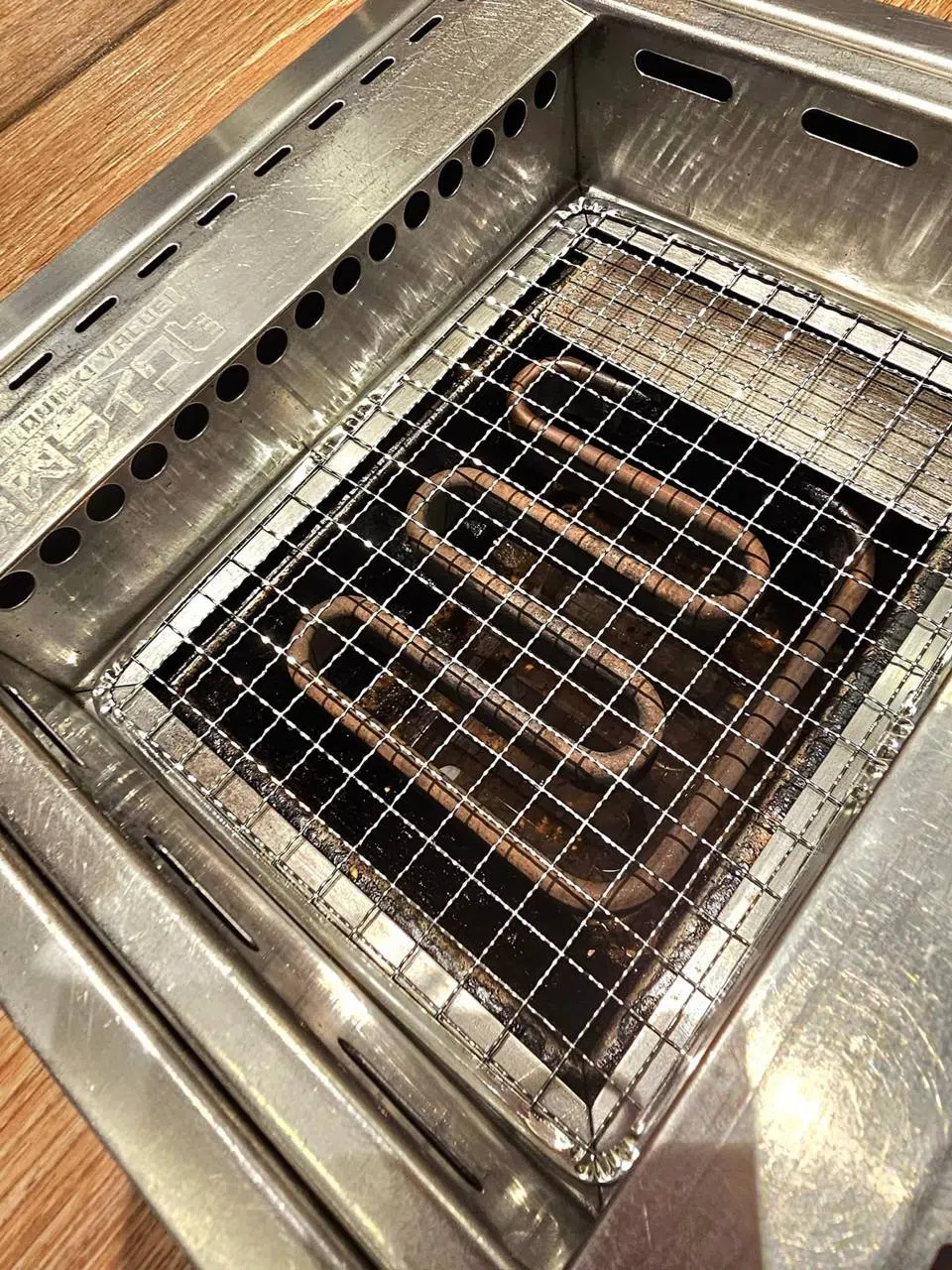 网友申诉，烤肉店并没有清理烤架下方的油渍。（取自脸书）