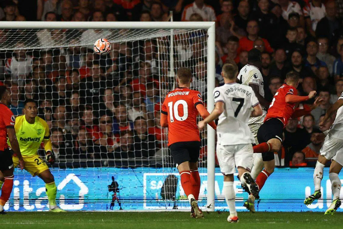 卢顿后卫安德森（右二）头球攻门得手。（法新社）