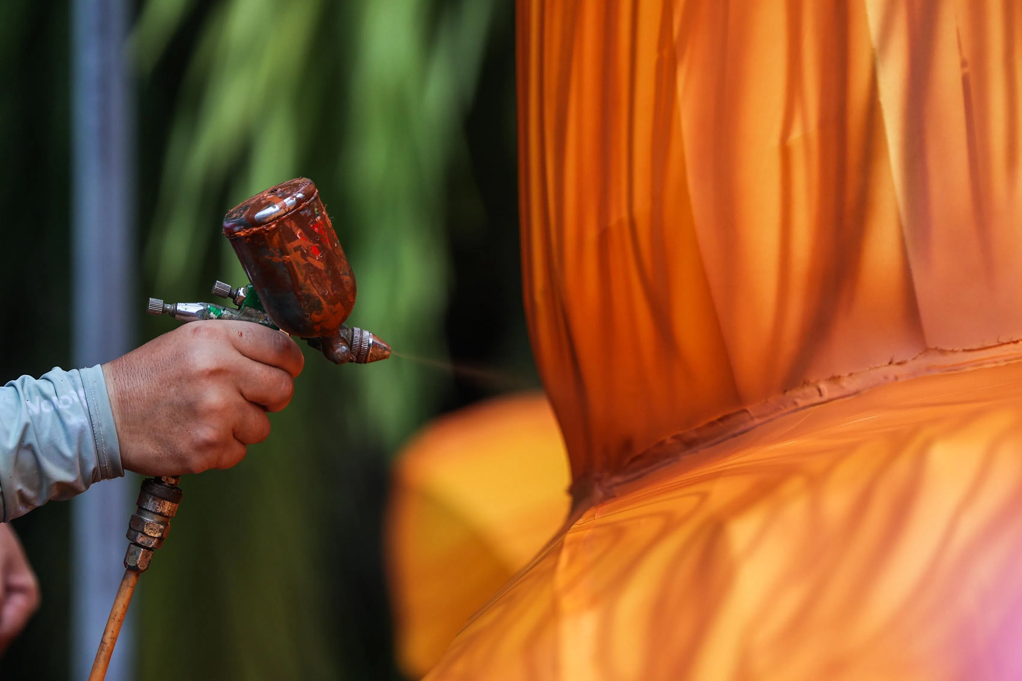 师傅在树干上一笔一画地将树的纹路以喷漆的方式画出来。（白艳琳摄）