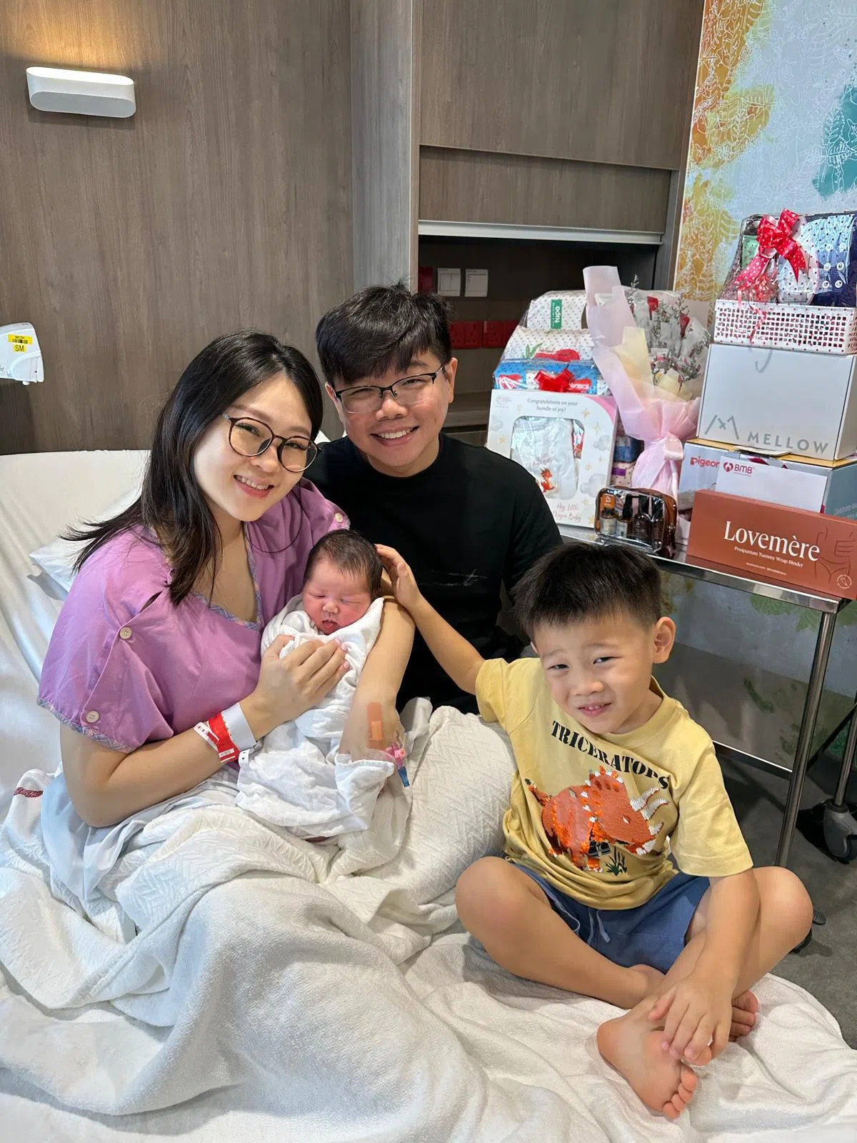 白伟思（左）和丘岳泽夫妇与大儿子一同迎接家中老幺的到来。（受访者提供）