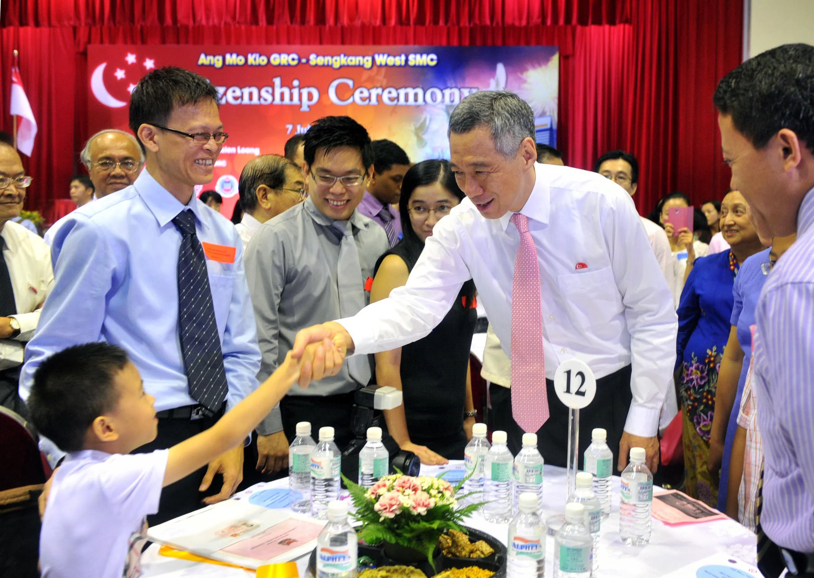 2012年7月，李显龙总理（右二）在德义民众俱乐部为宏茂桥及盛港西的200多名新公民主持宣誓仪式。那是他自2004年当总理八年来，首次以总理身份主持新公民宣誓仪式。（档案照片）