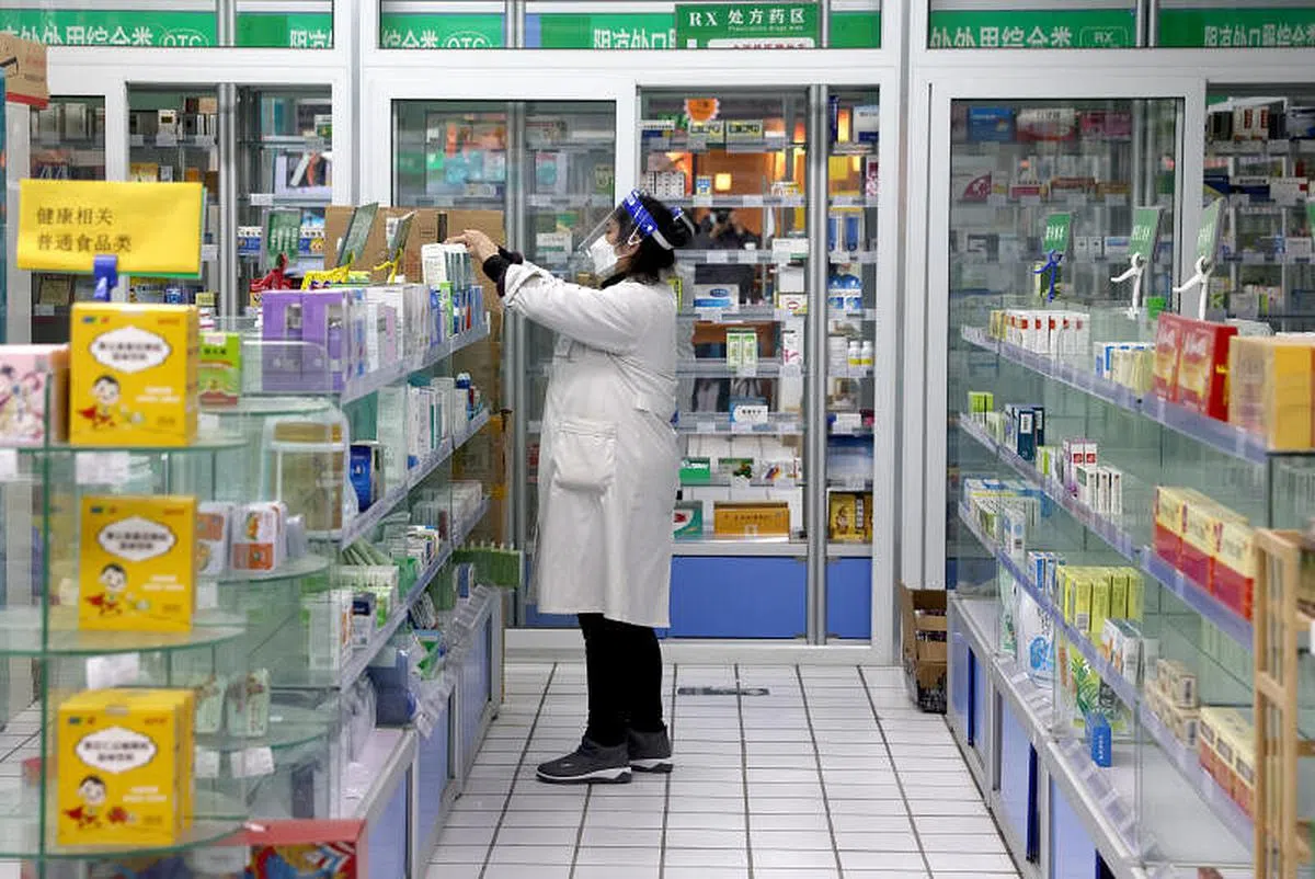 12月7日，北京一家药店的工作人员在整理药品。（中新社）