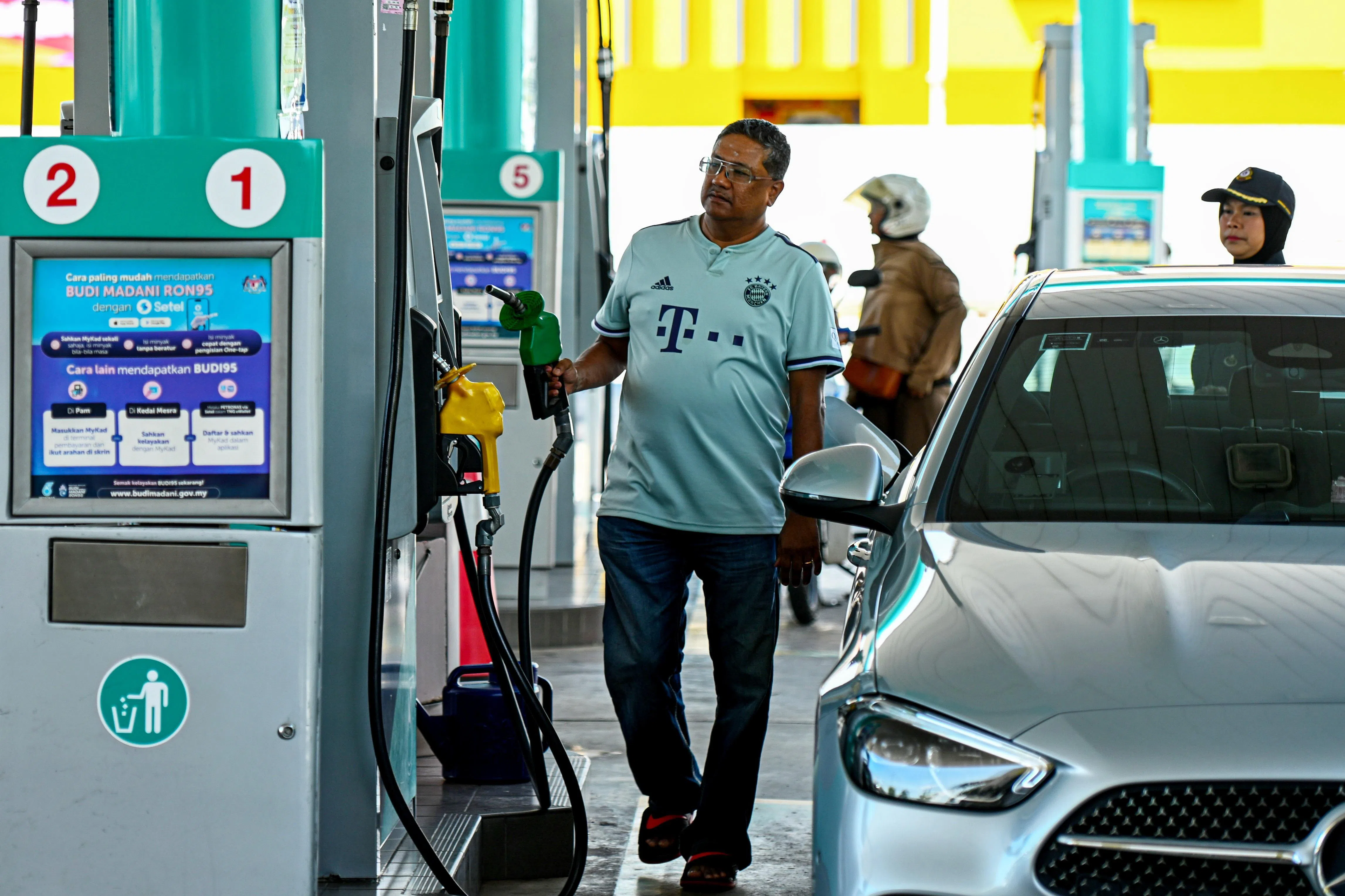 新加坡车主古马星期四（4月9日）在森美兰州芙蓉，遵守规定添购不受补贴的RON97汽油。马来西亚从4月1日起，严禁包括新加坡车在内的外国注册车辆在马国境内添加受补贴的RON95汽油，也禁止车主使用海外信用卡或转账卡在泵岛直接添油。（马新社）