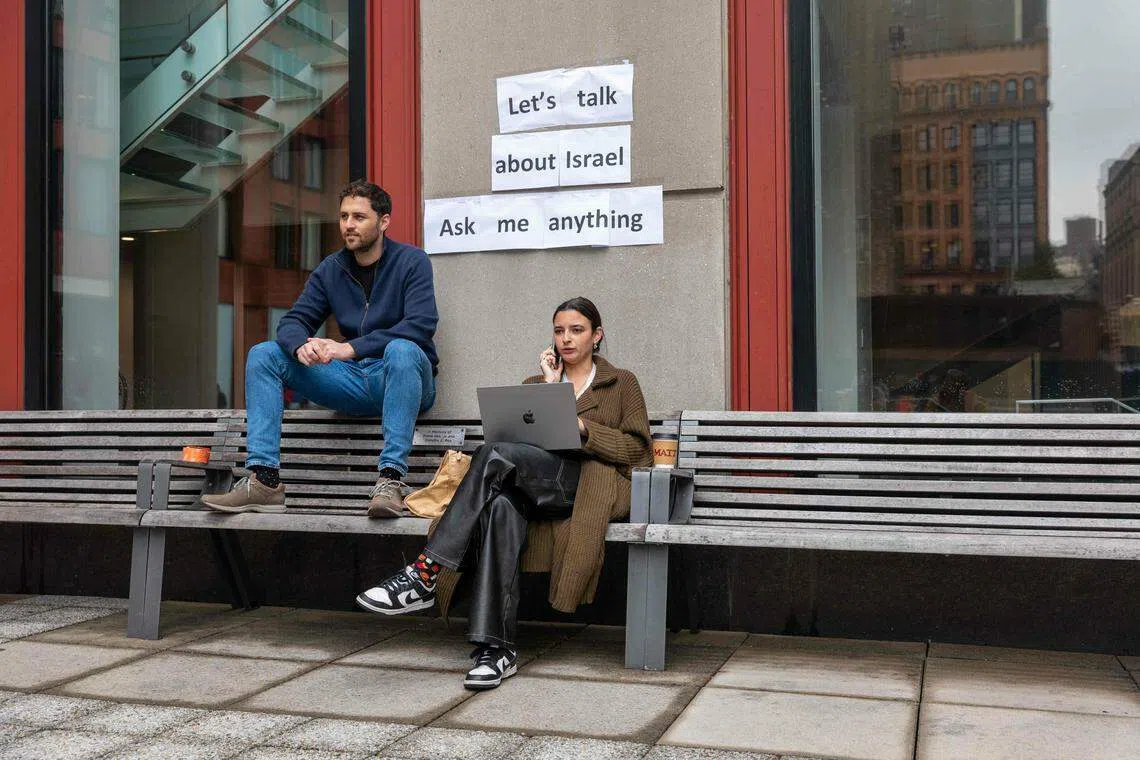 10月30日，纽约大学的两名以色列学生在校园内办了一场活动，希望和学生们讨论以色列。墙上的标语写道：“我们来谈谈以色列吧。可以问我任何问题。”（法新社）