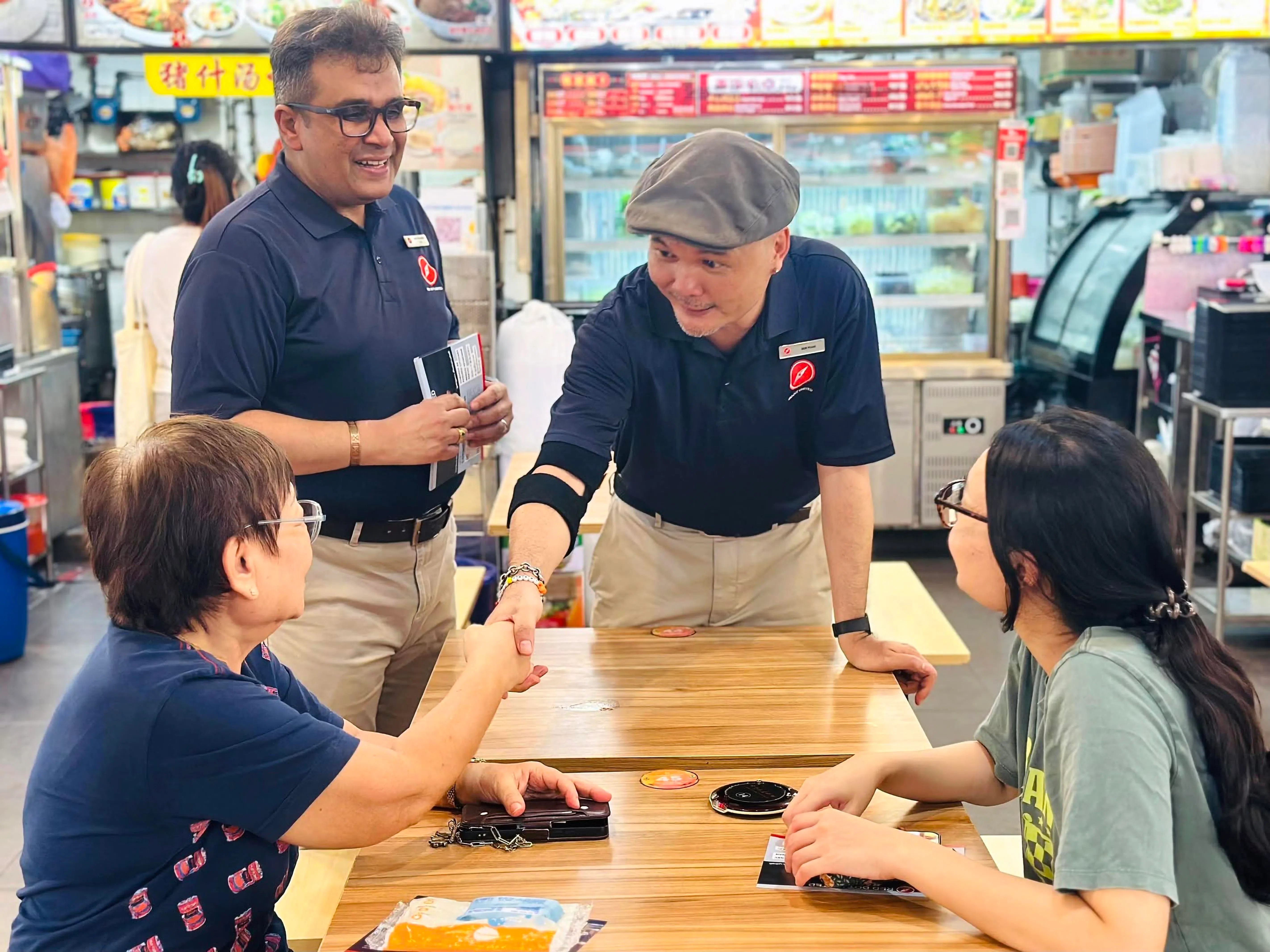 潘家定（右二）与“红点同心党”党员2025年竞选时与民众互动。（受访者提供）