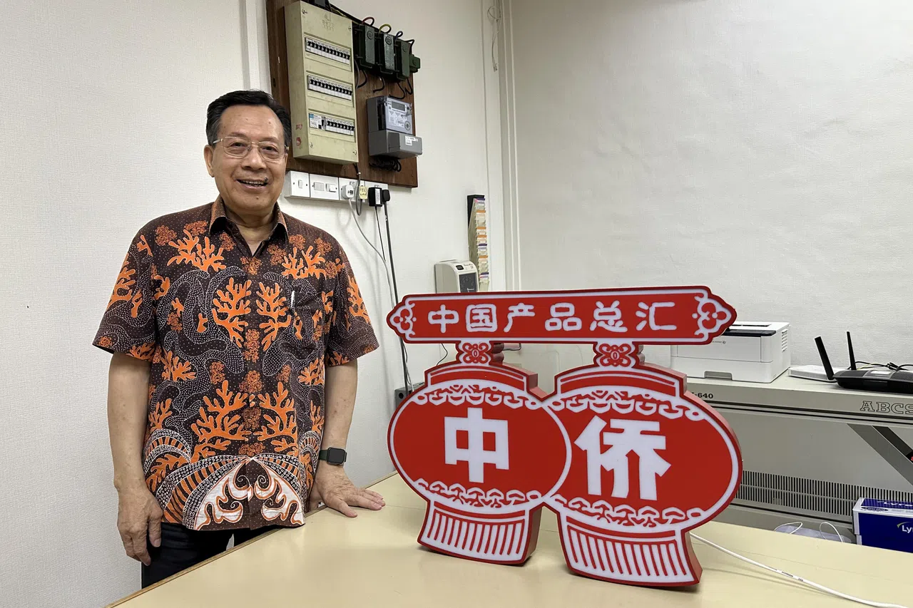 中侨集团董事总经理林方华和中侨百货的标志性灯牌。（苏姗摄）
