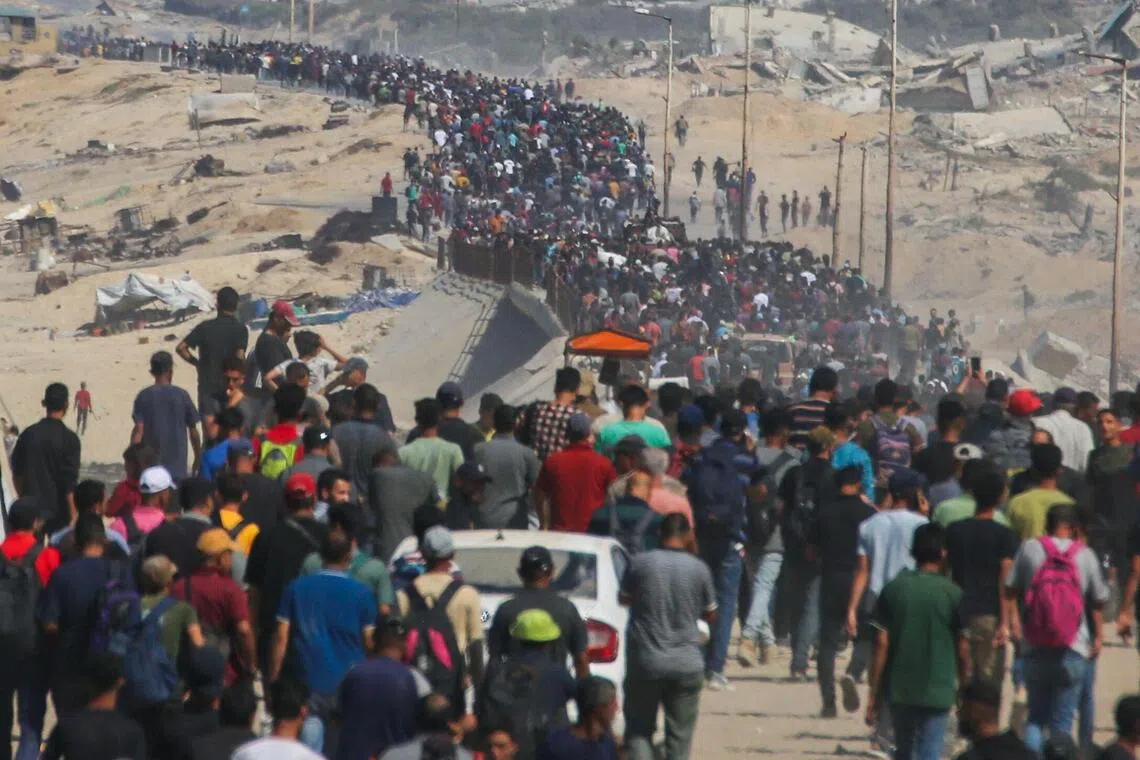 数以千计转移至南方的加沙城人周五涌上拉希德（Al-Rashid）公路，要回返加沙城里的家园。（法新社）