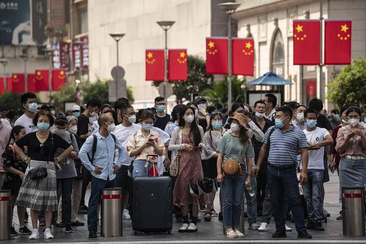 中国国庆黄金周期间人员流动增加，造成中国大陆本土疫情升温。图为10月2日游客在中国上海的南京路上行走。（彭博社） 