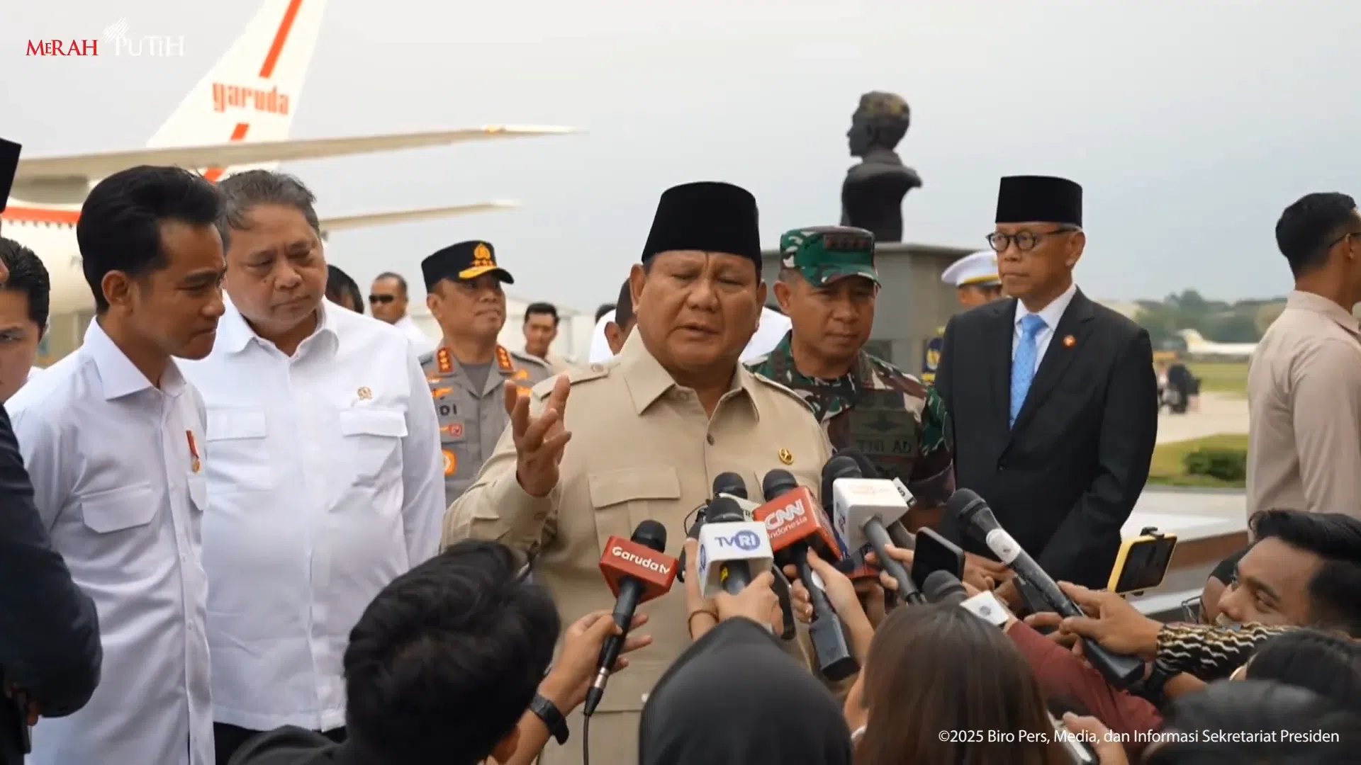 2025年9月27日，印尼总统普拉博沃（图中黄衣者）结束海外访问回国，在机场接受媒体访问，回答出访成果与免费营养餐食物中毒问题。（印尼总统秘书处直播截图）
