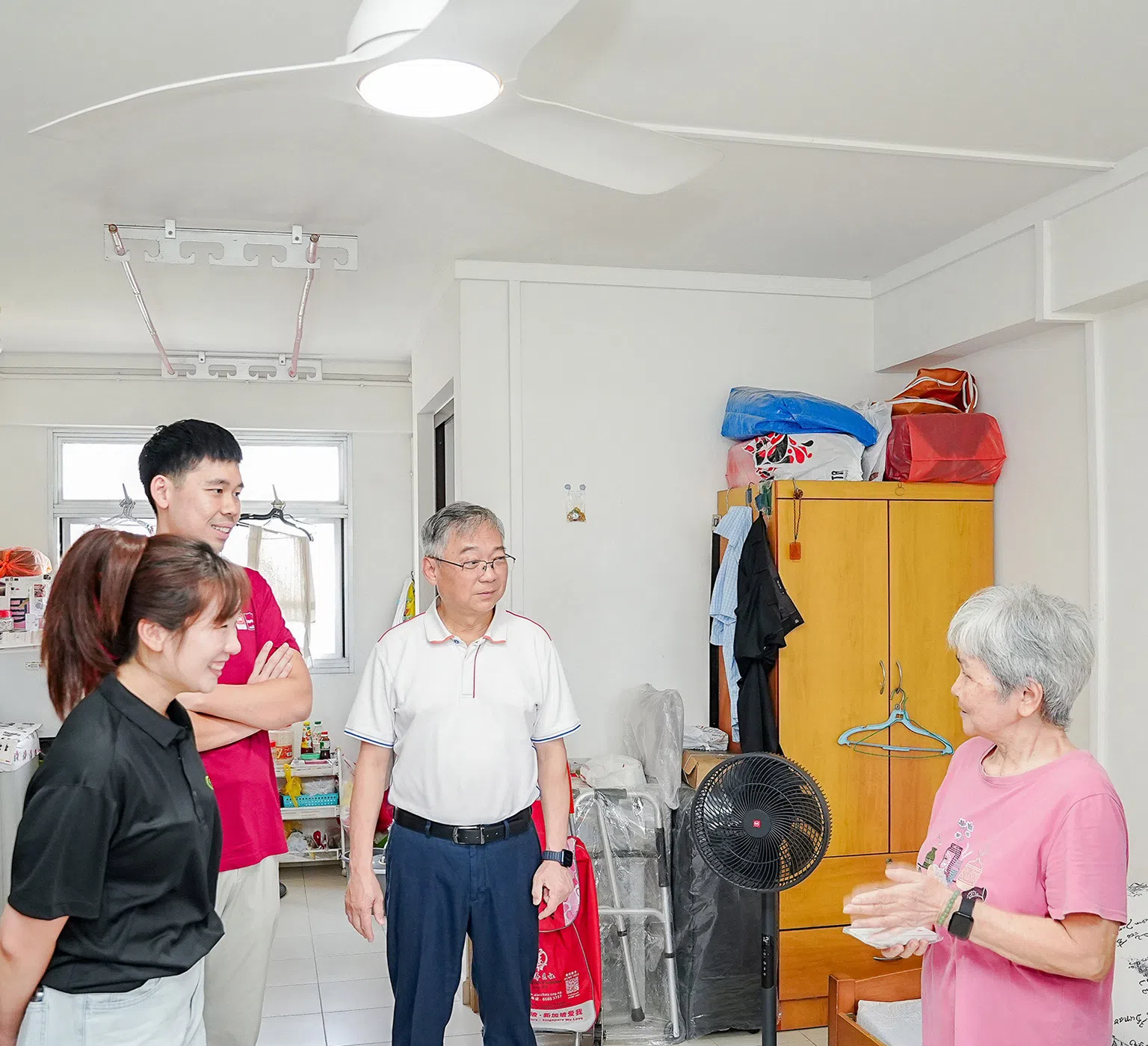 DPM Gan Kim Yong and Capital Distributors General Manager Lim Weili, SL2 representative Celeste Koh visiting resident Chang Nguk Lan at her home.
