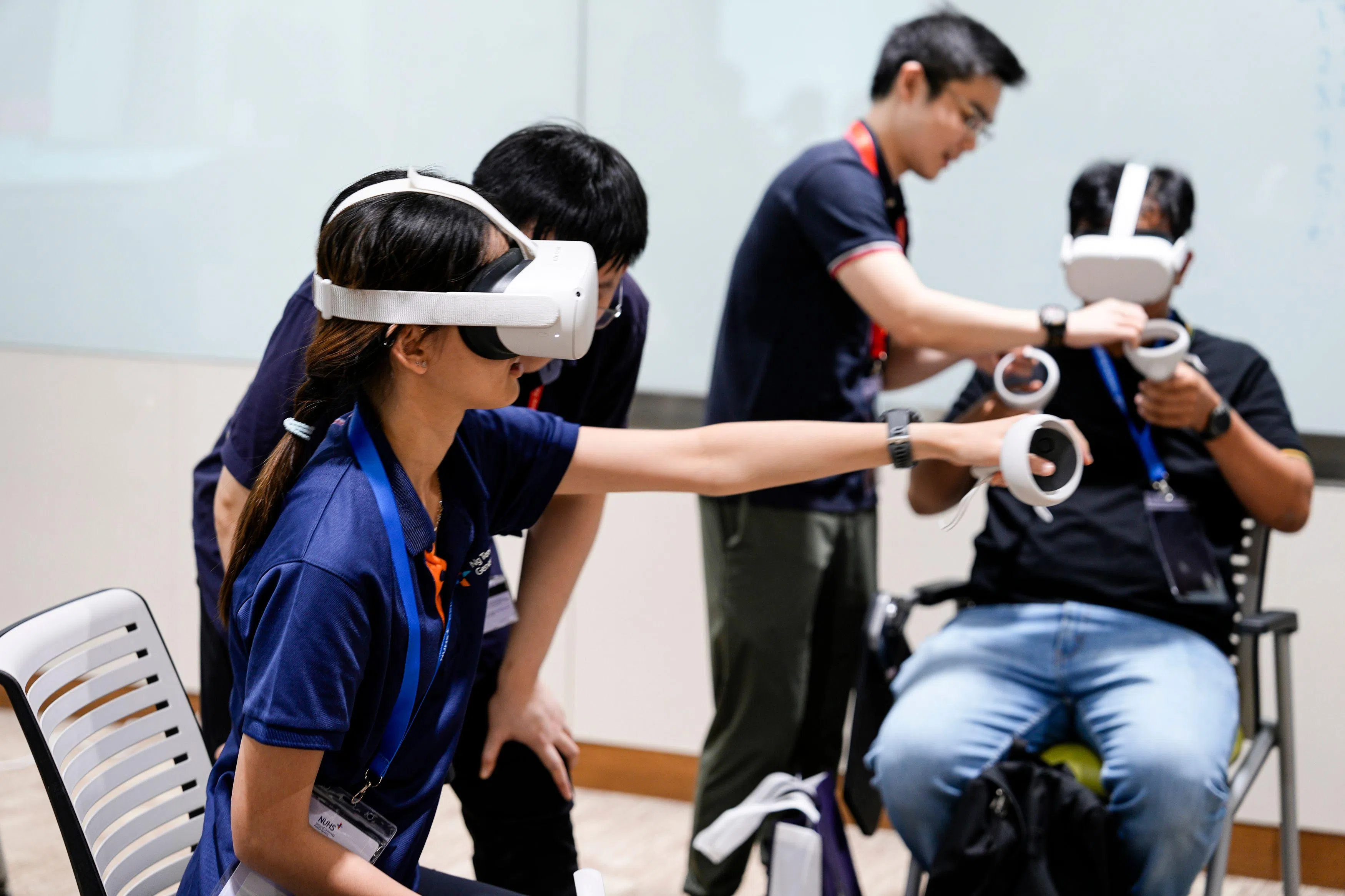 在研讨会现场，护士戴上虚拟实境的设备，在数码空间练习为病患处理伤口和导尿等临床工作。（国大医学组织提供）