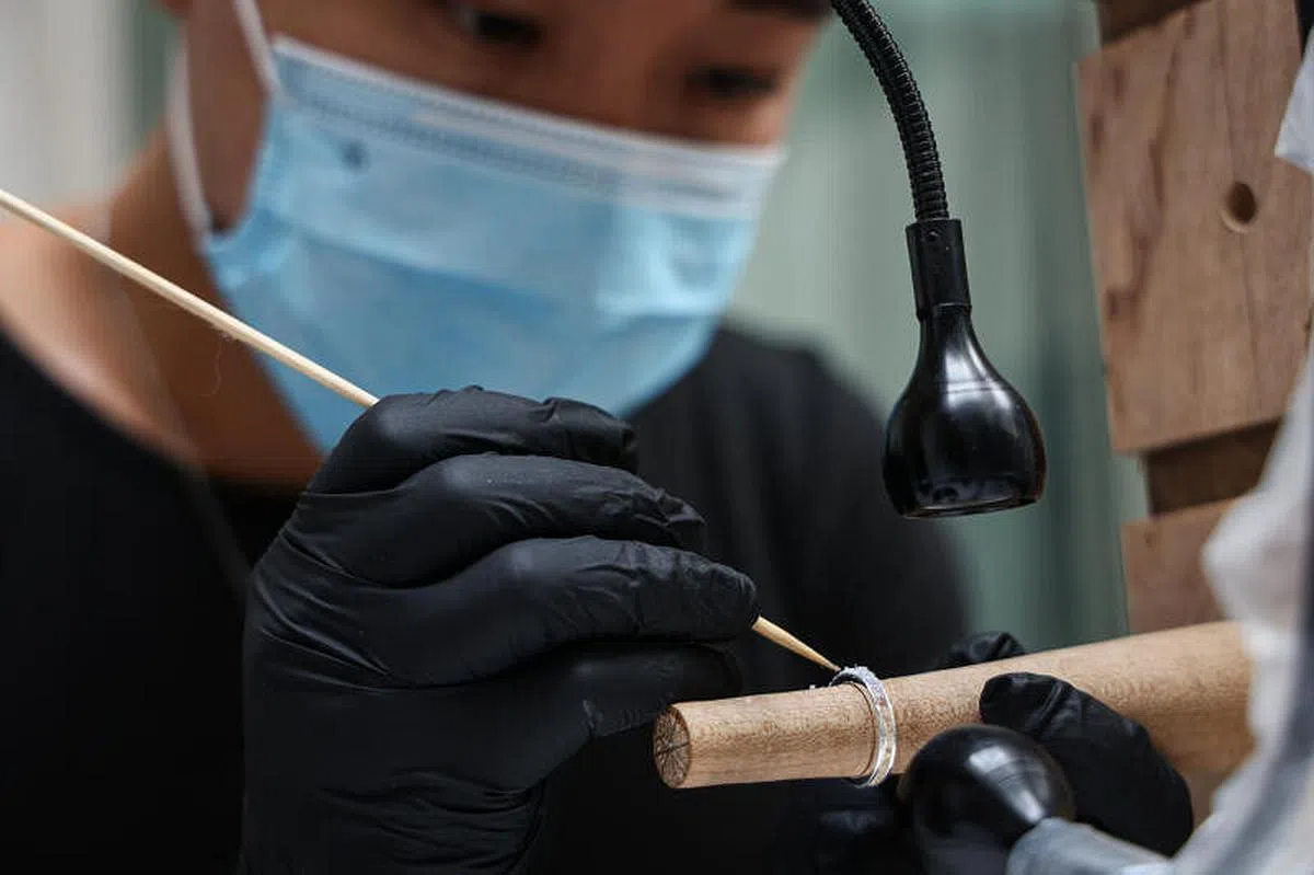 林宗翰在骨灰上覆盖一层碎欧泊，固定后将逝者的回忆磨得亮晶晶。 （李健玮摄）