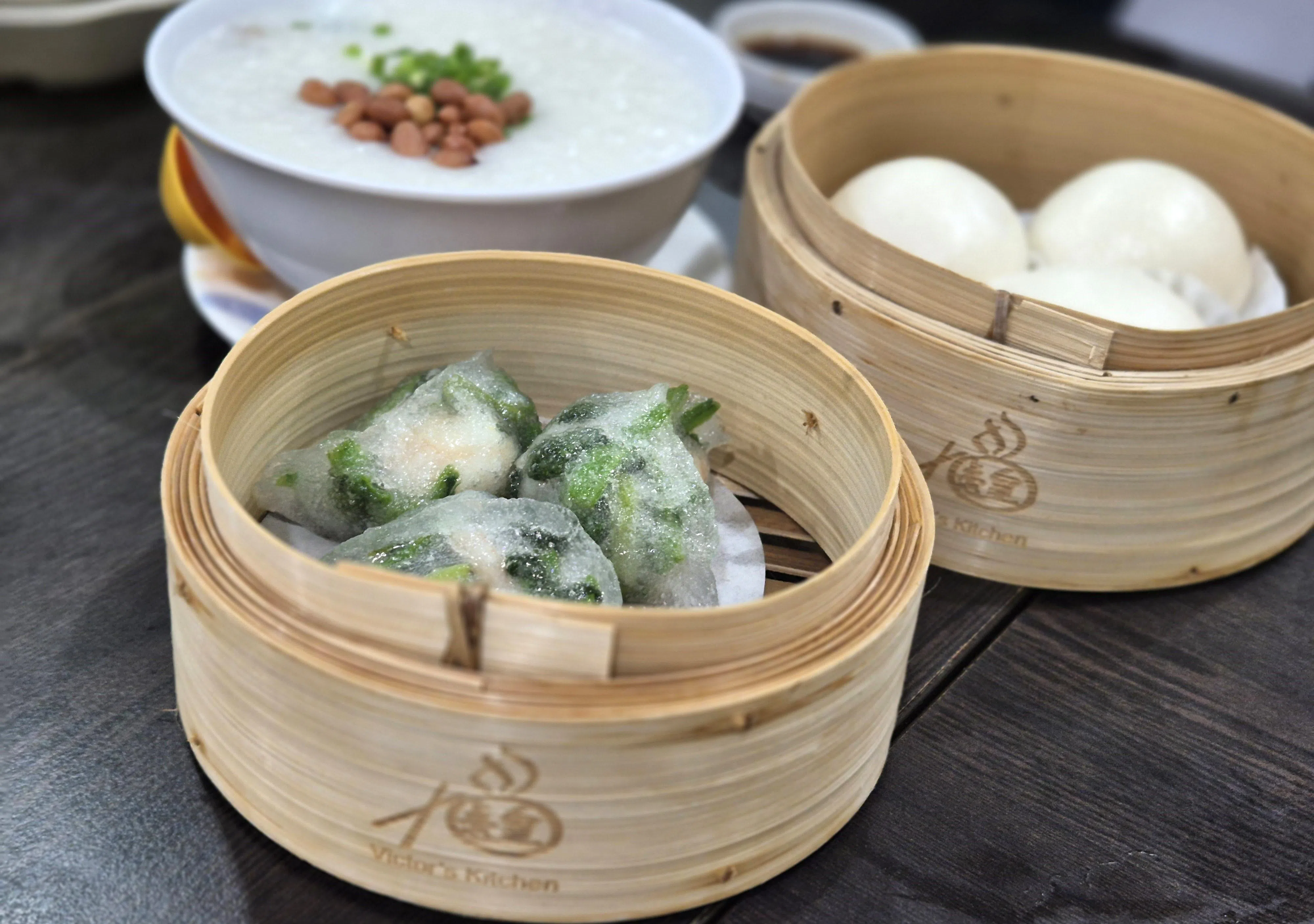 “点心皇”的鲜虾菠菜饺（前）、得奖黄金流沙包（右）和港式粥品也受顾客喜爱。（陈爱薇摄）